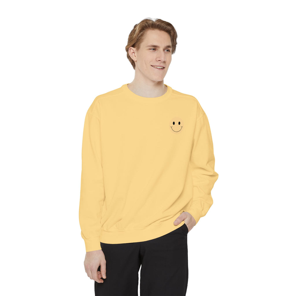 Person wearing a yellow sweatshirt with a smiley face emblem on a white background