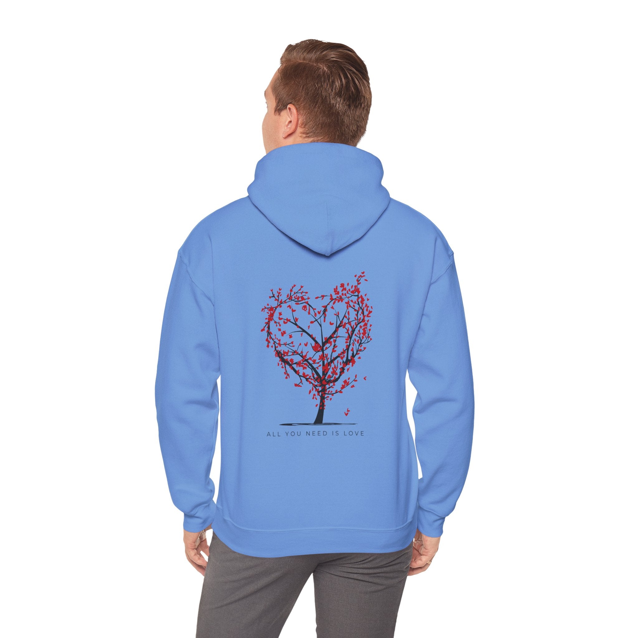 Person wearing a blue hoodie with a tree design on the back, standing against a white background