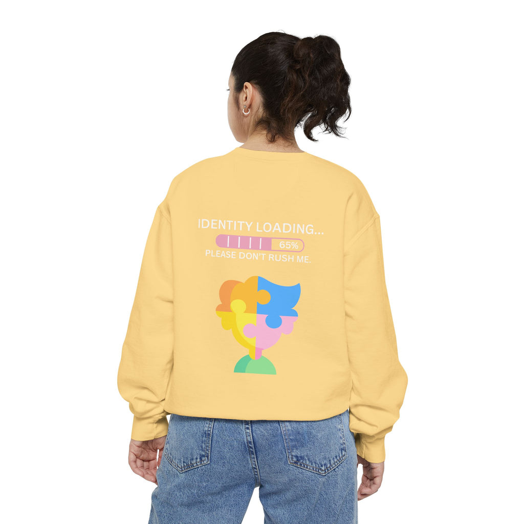 Person wearing a yellow sweatshirt with a colorful puzzle design and text on the back.