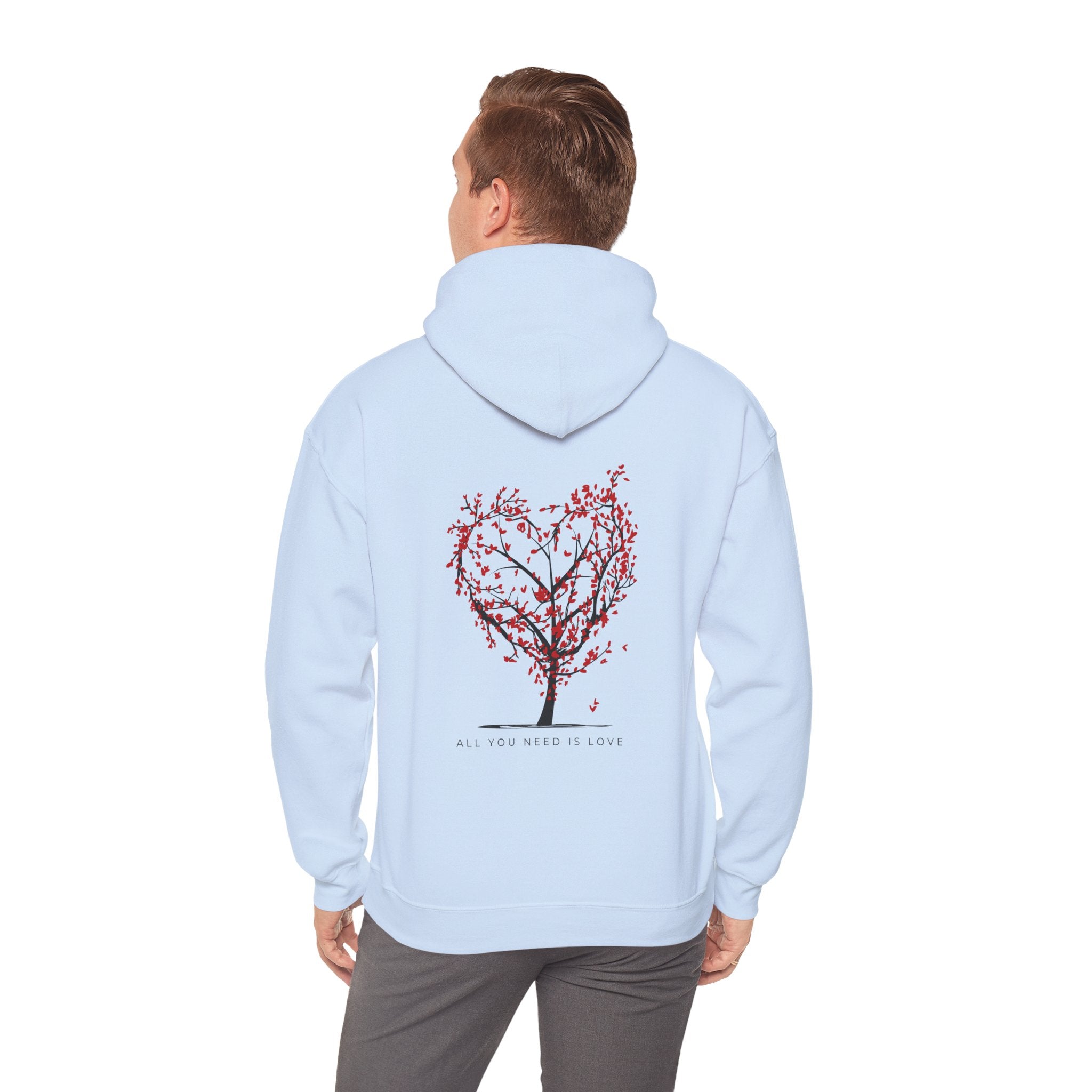 Light blue hoodie with a red tree design on the back, worn by a person.