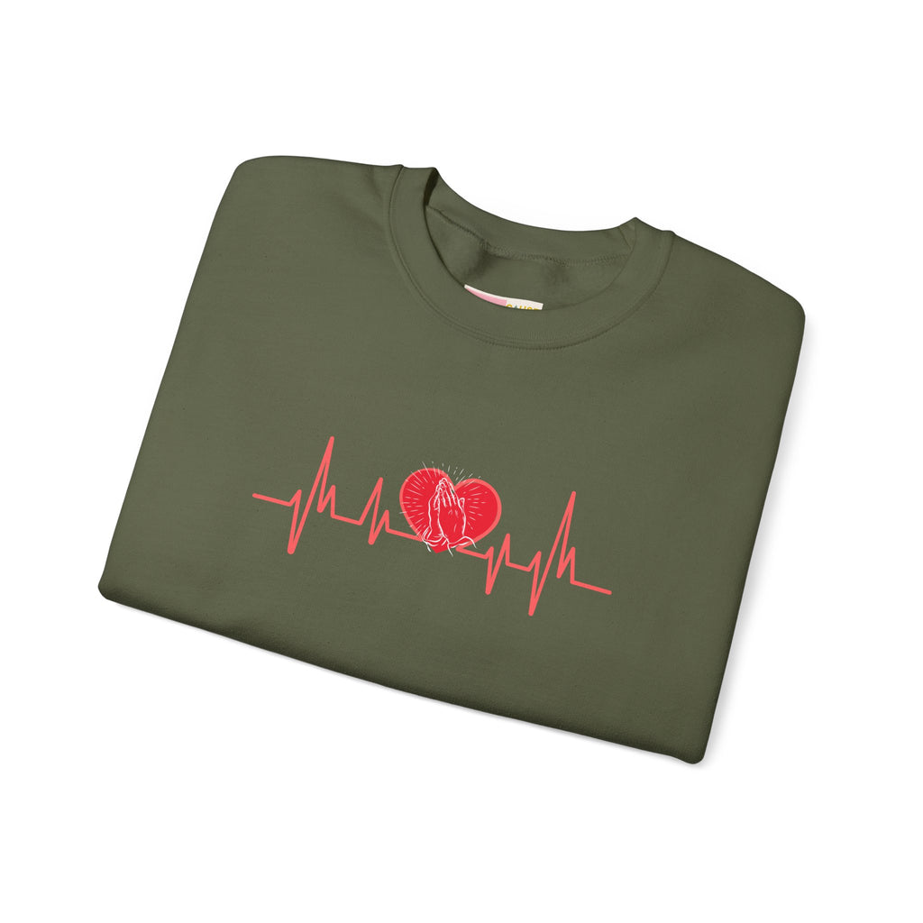 Folded green sweatshirt with red heart and heartbeat line design on a white background