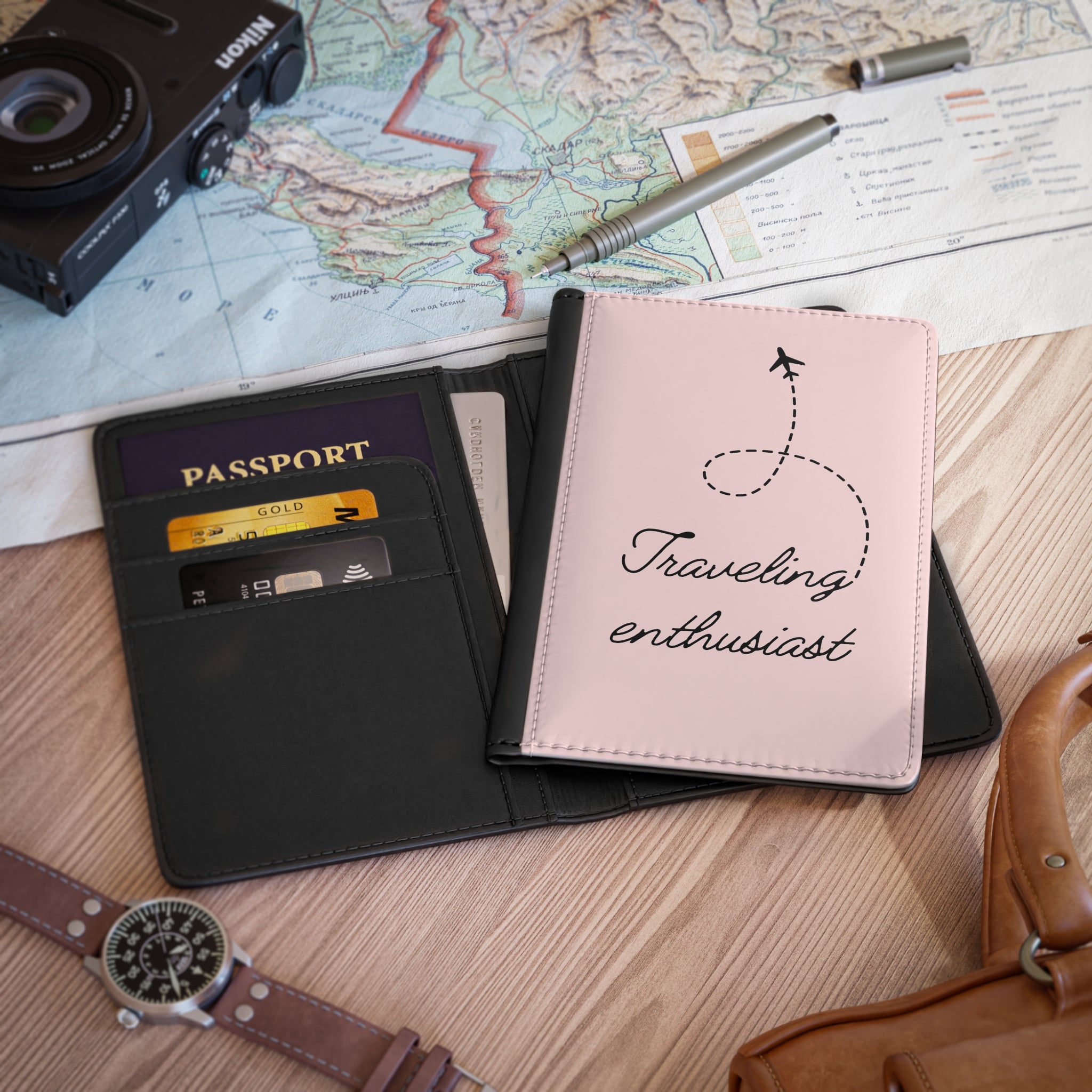 Passport holder with 'Traveling enthusiast' text on a map and camera background