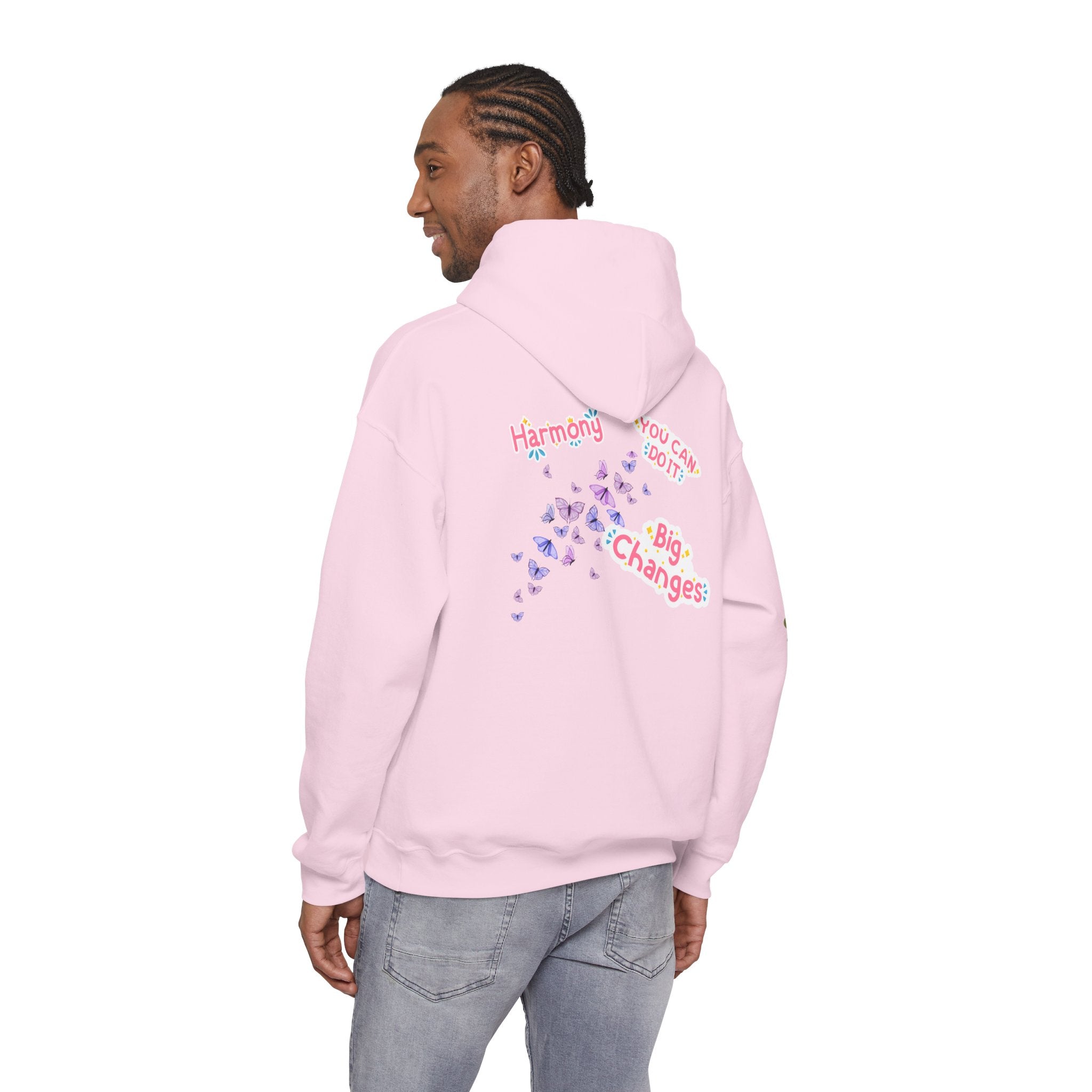 Person wearing a pink hoodie with text and graphics on the back, standing against a white background