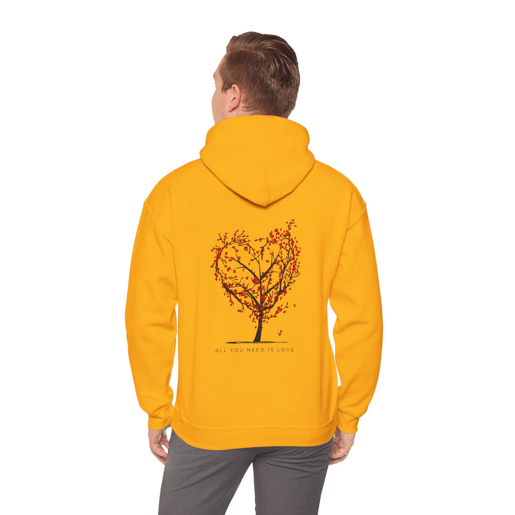 Person wearing a yellow hoodie with a tree design on the back against a white background