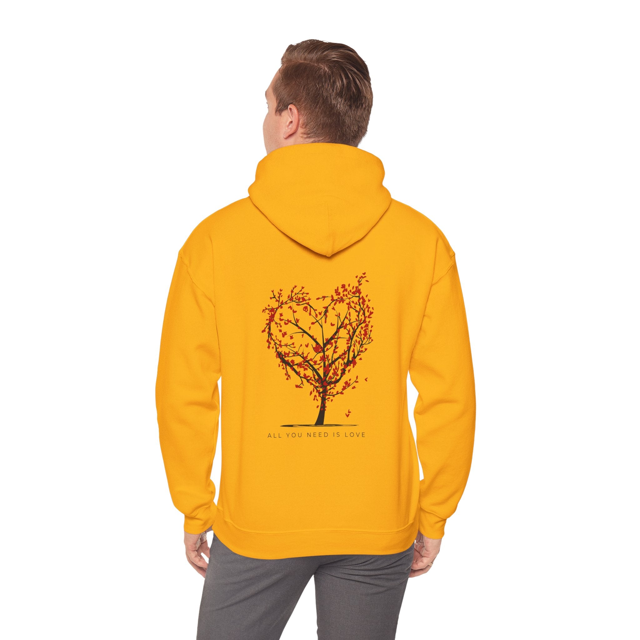 Person wearing a yellow hoodie with a tree design on the back against a white background