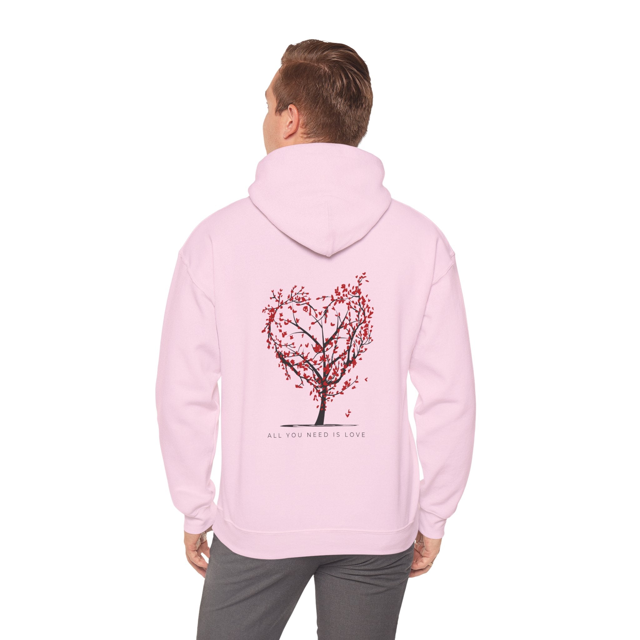 Person wearing a pink hoodie with a tree design on the back against a white background