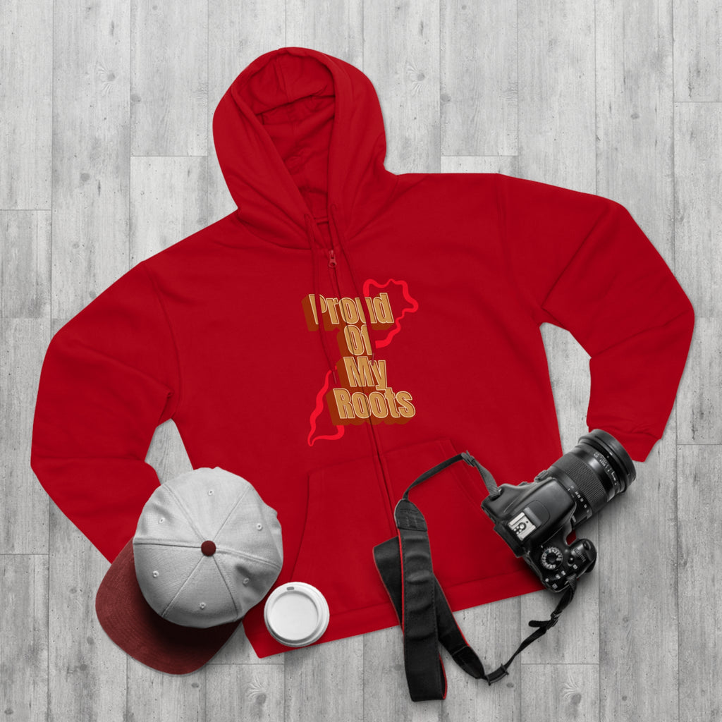 Red hoodie with 'Proud of My Roots' text, white cap, white cup, and camera on a wooden surface