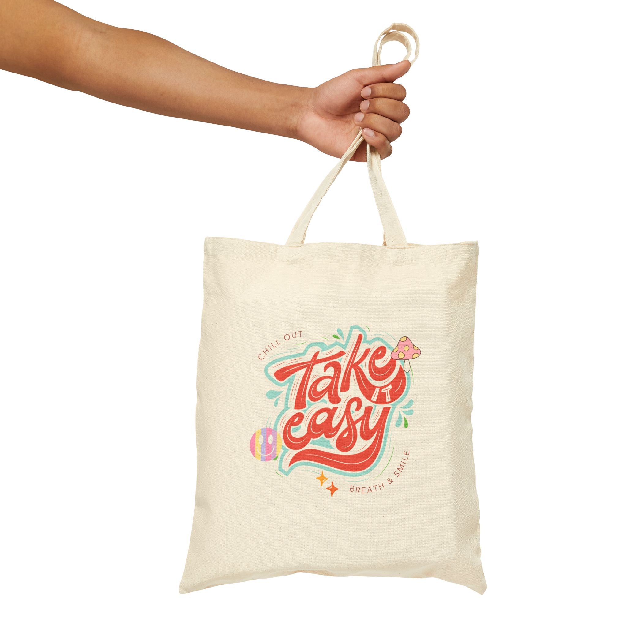 Tote bag with 'Take easy' design held by a hand on a white background