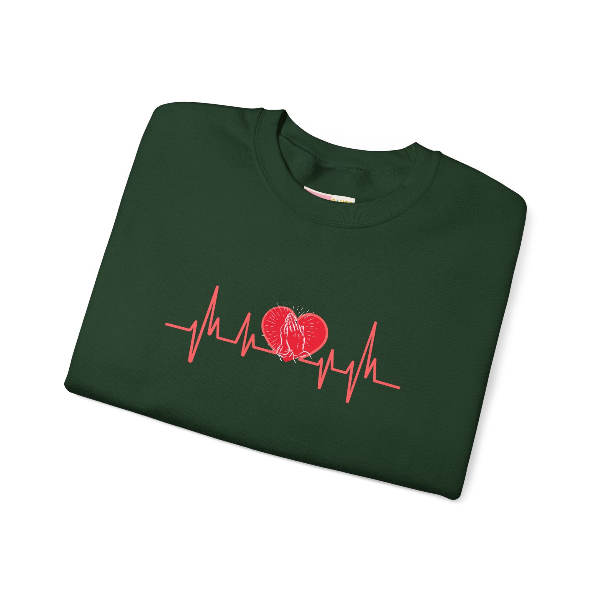 Folded green sweatshirt with red heart and heartbeat line design on a white background