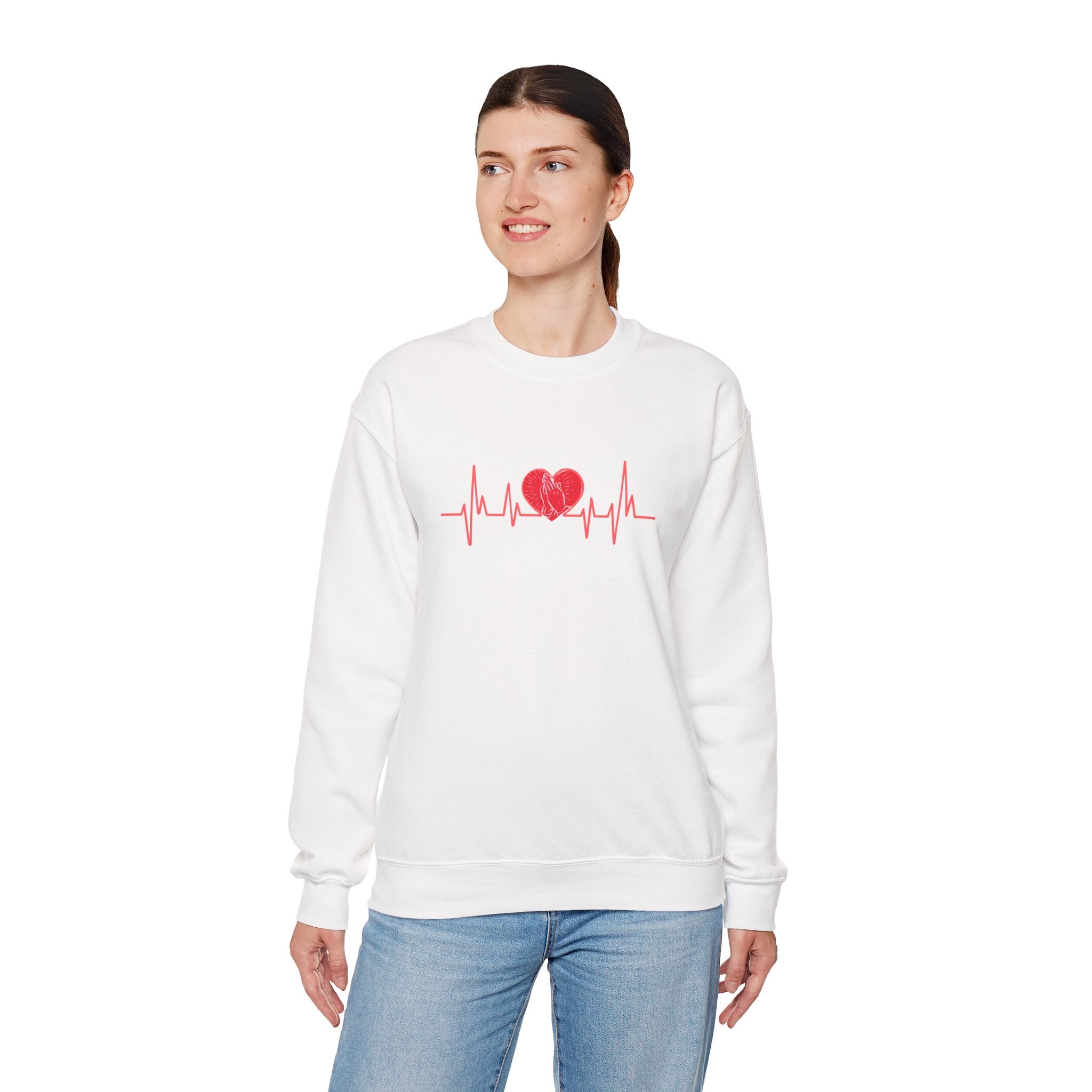 Woman wearing a white sweatshirt with a red heart and line design on a white background