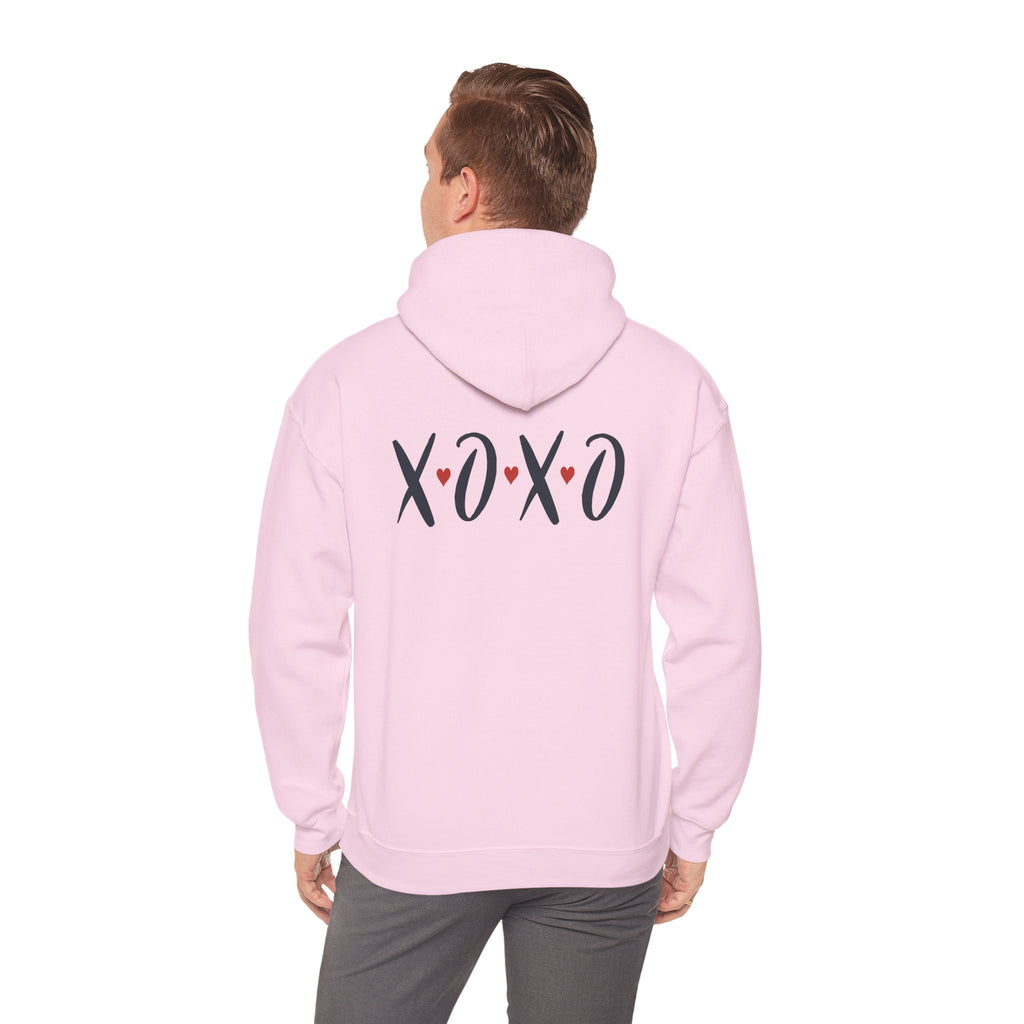Person wearing a pink hoodie with 'XOXO' text on the back, standing against a white background