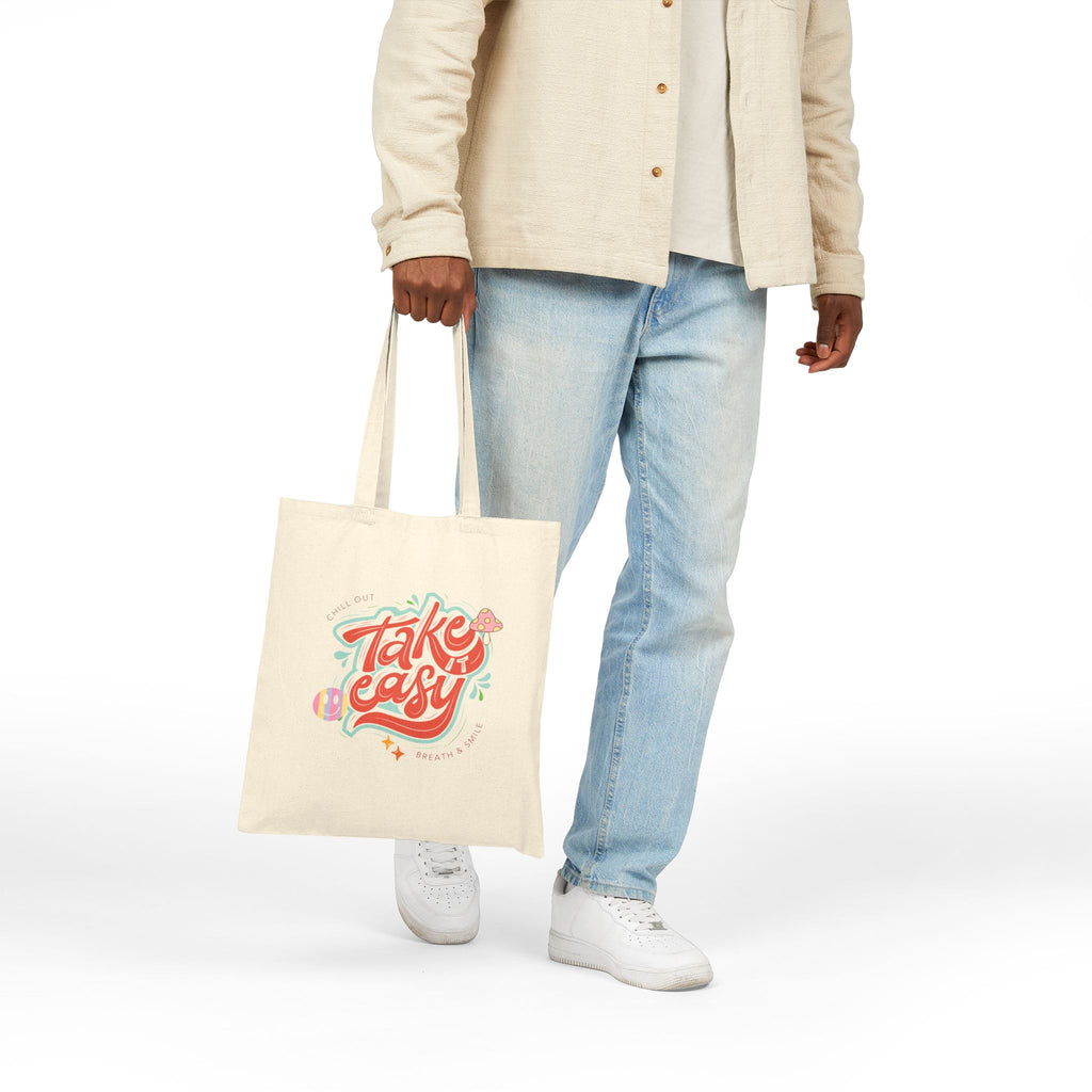 Person holding a tote bag with 'Take It Easy' text on a white background