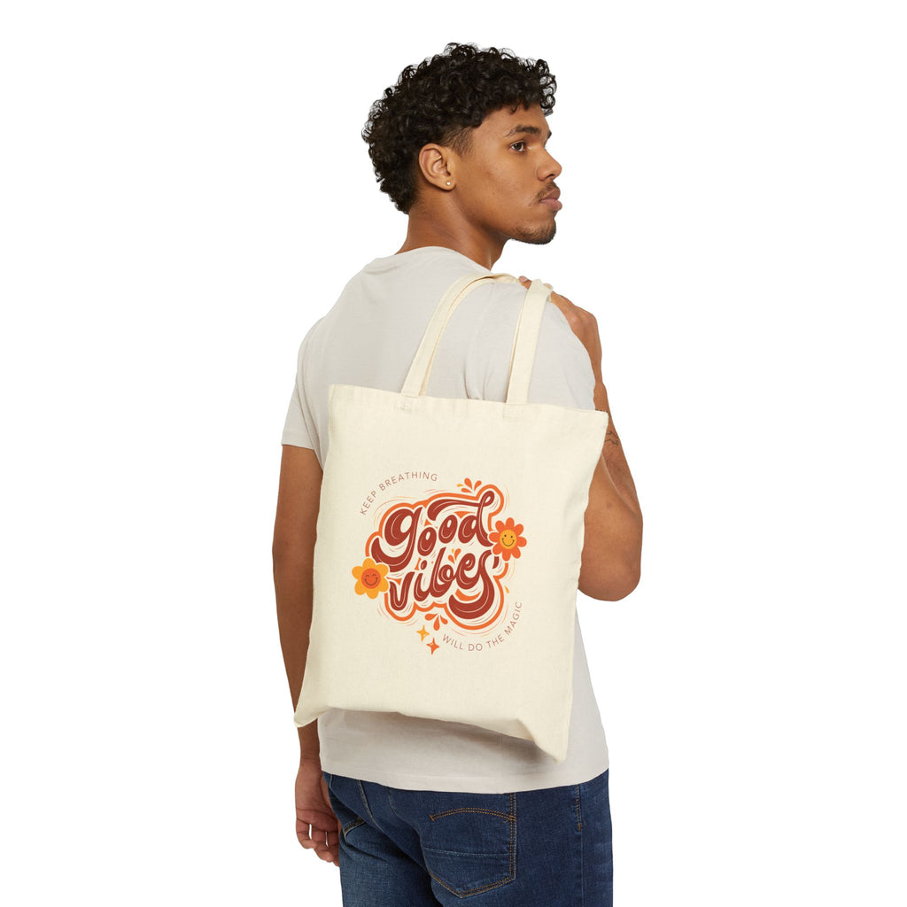 Man carrying a tote bag with 'Good Vibes' text on a white background