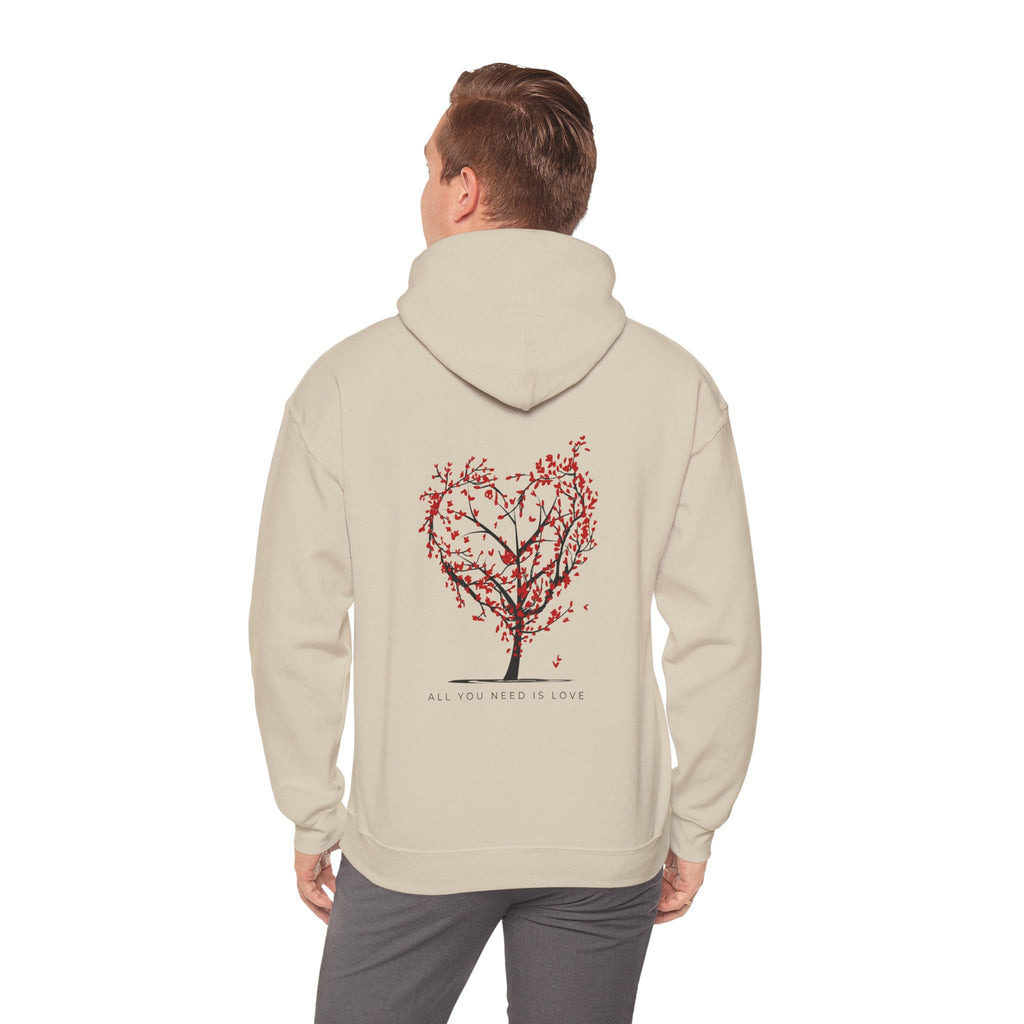 Person wearing a beige hoodie with a tree design on the back against a white background