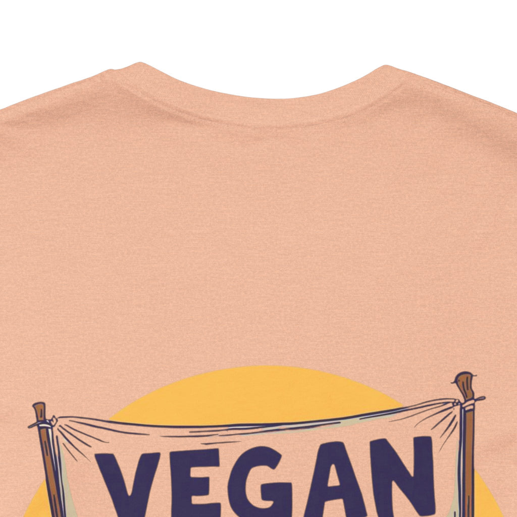 Beige t-shirt with 'VEGAN' banner design on a plain background