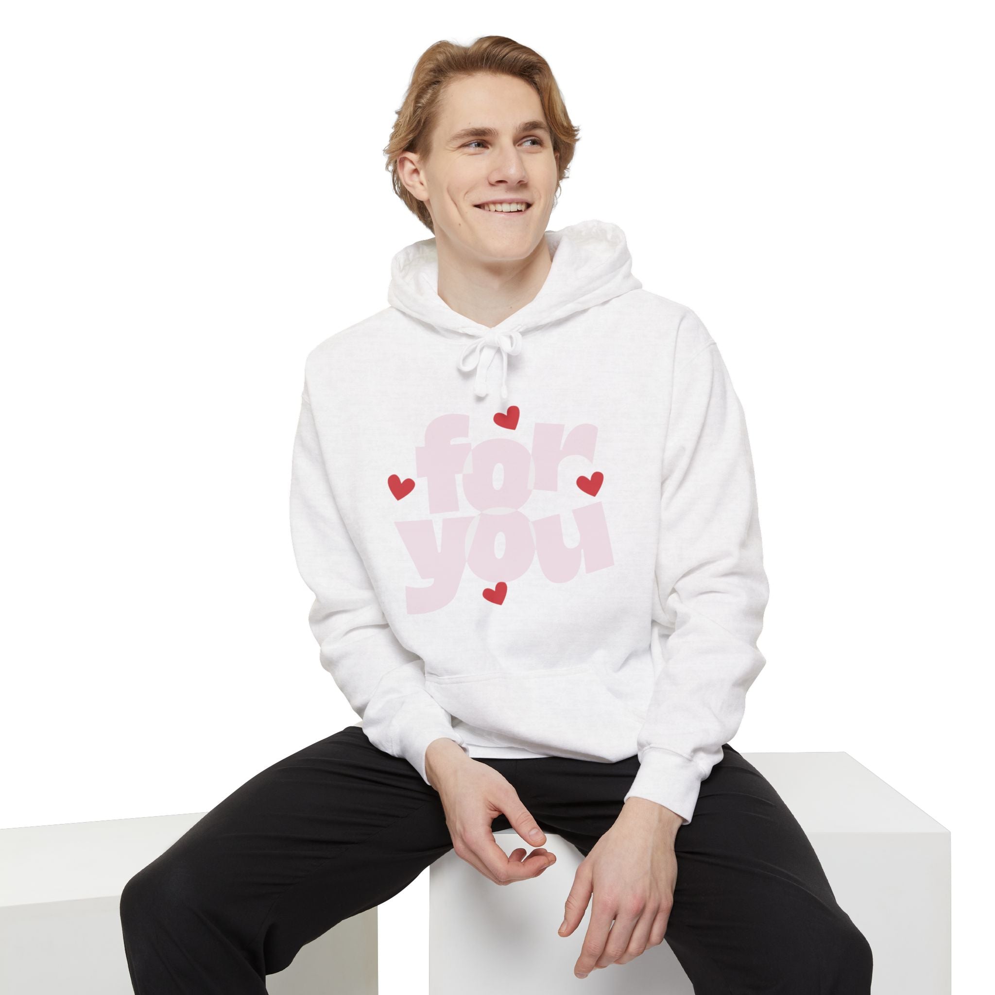 Person wearing a white hoodie with pink text and hearts on a white background