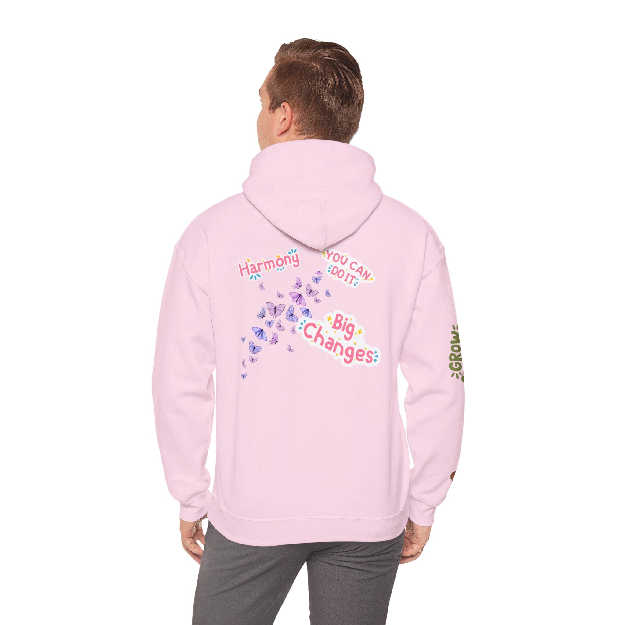 Person wearing a pink hoodie with text and graphics on the back, standing against a white background