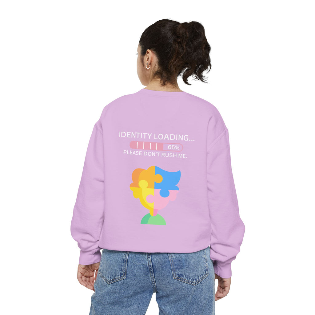 Person wearing a pink sweatshirt with a colorful graphic and text on the back, standing against a white background.