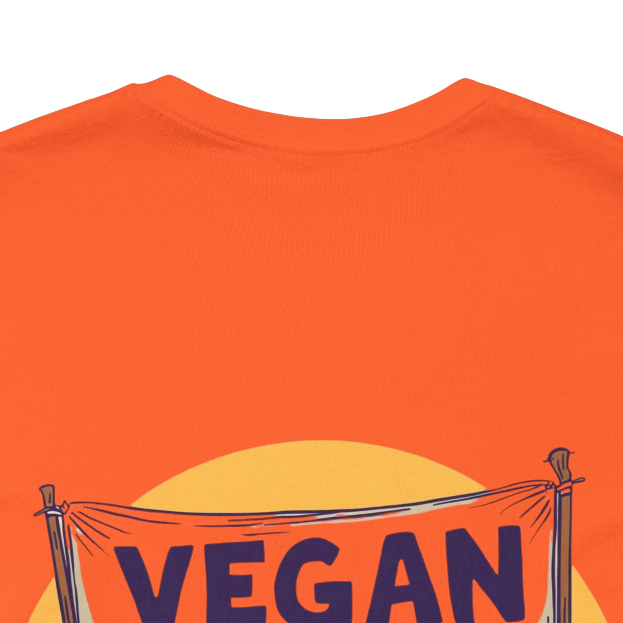 Orange t-shirt with a 'VEGAN' banner design on a white background