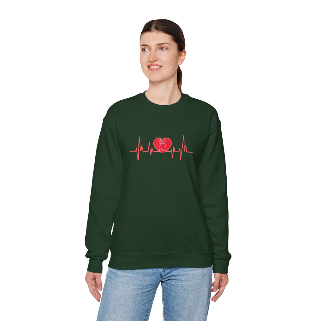 Person wearing a green sweatshirt with a red heart and heartbeat line design on a white background