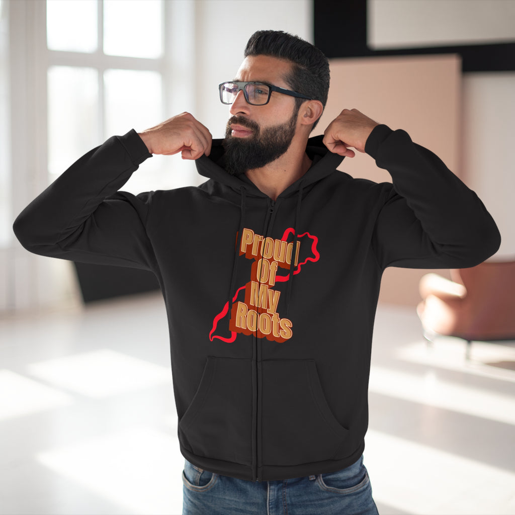 Man wearing a black hoodie with 'Proud of My Roots' text and graphic, indoors.