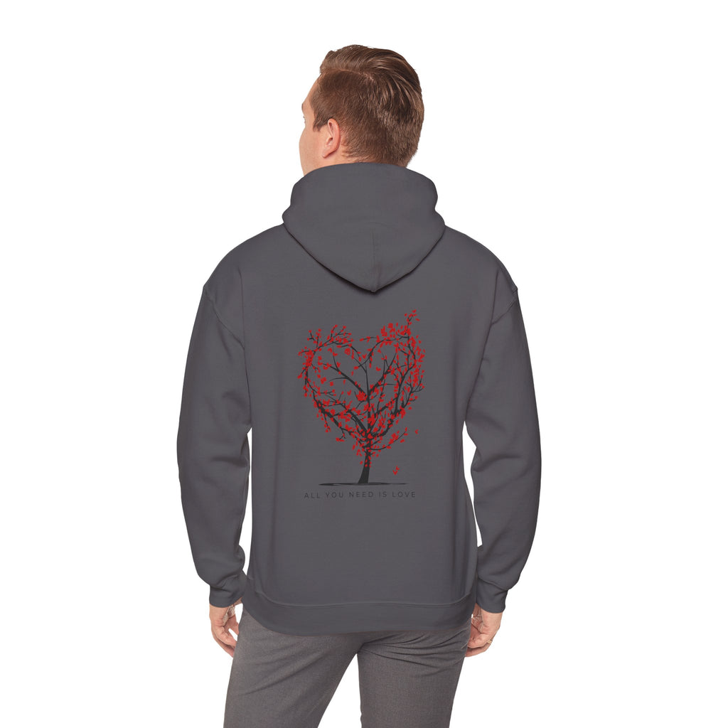 Person wearing a gray hoodie with a red tree design on the back against a white background