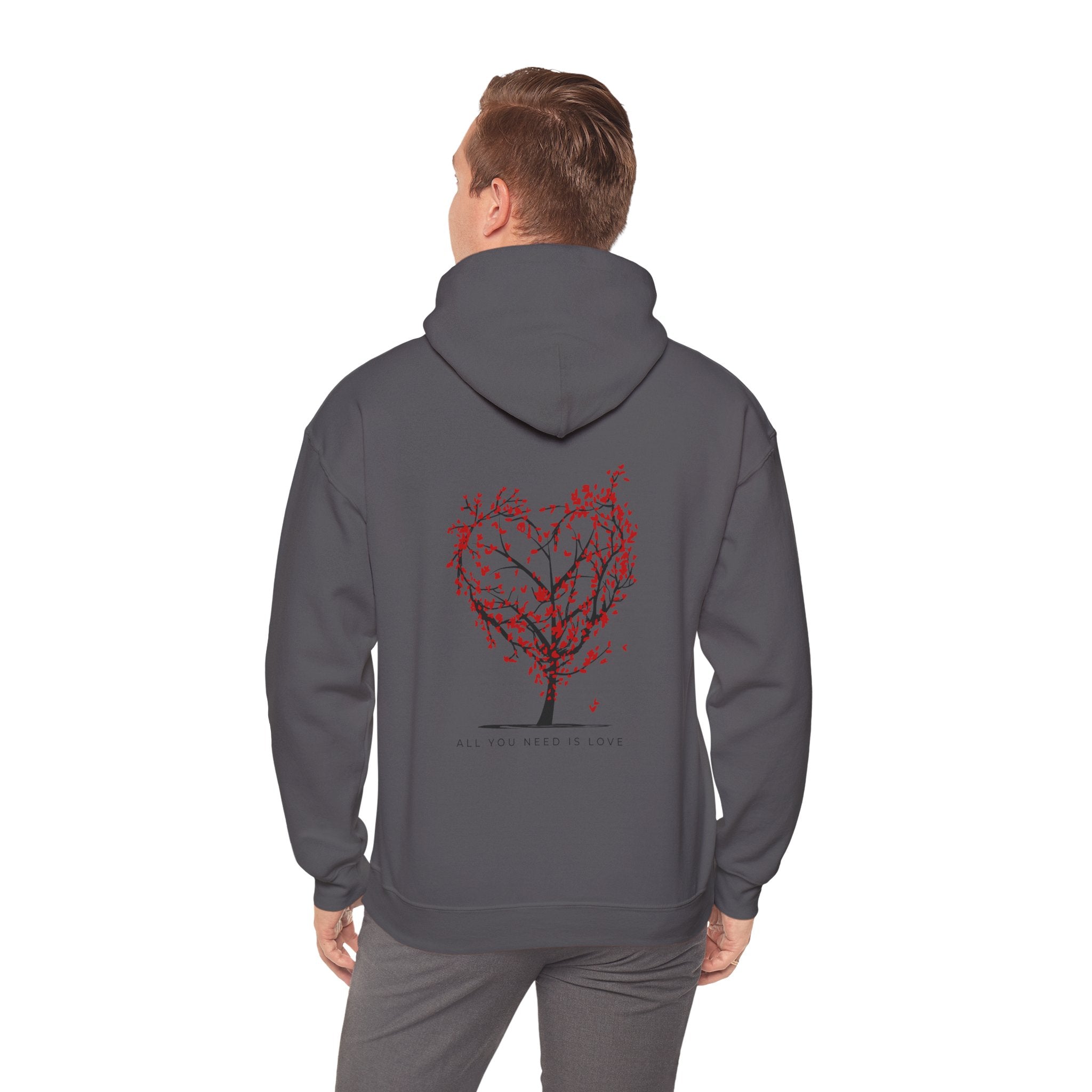 Person wearing a gray hoodie with a red tree design on the back against a white background