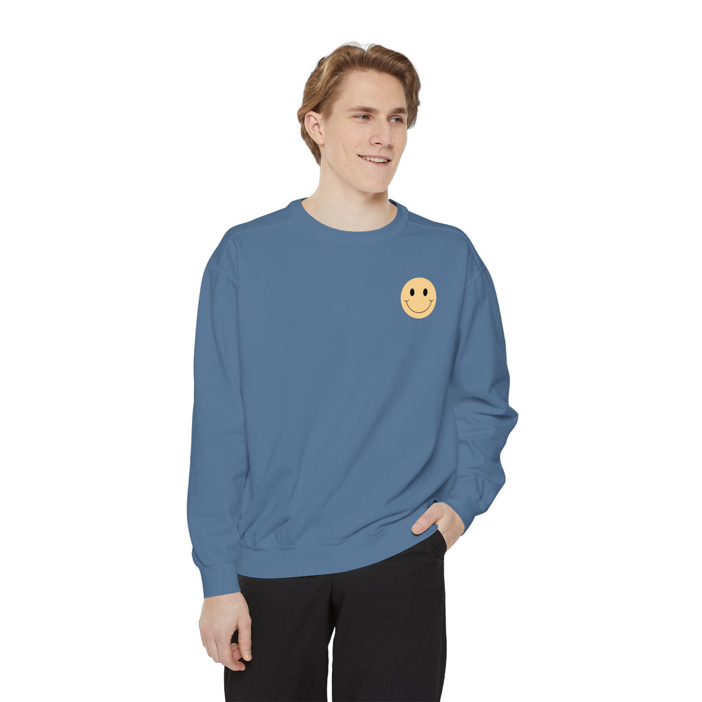 Person wearing a blue sweatshirt with a smiley face emblem on a white background