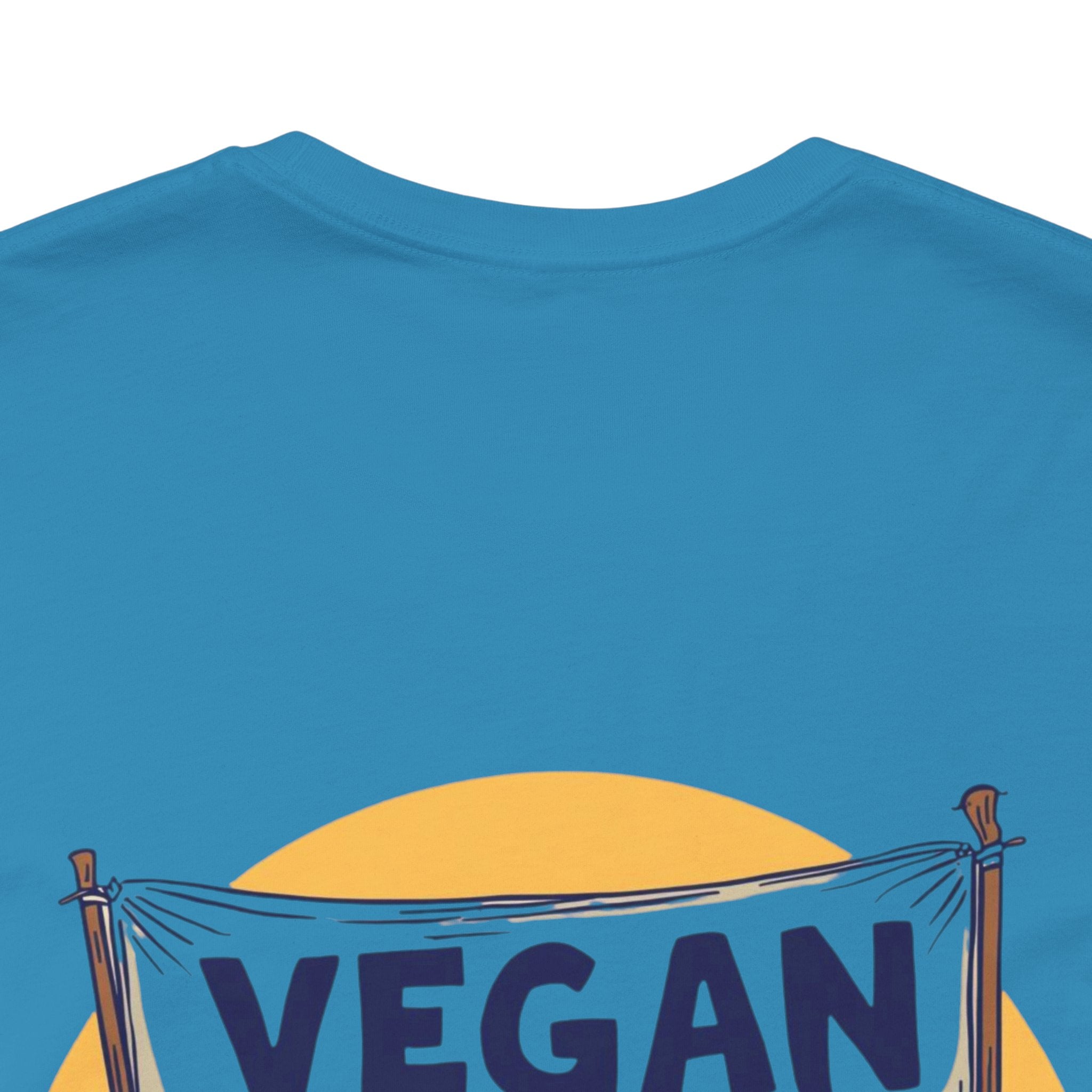 Blue t-shirt with a yellow circle and 'VEGAN' text on a white background