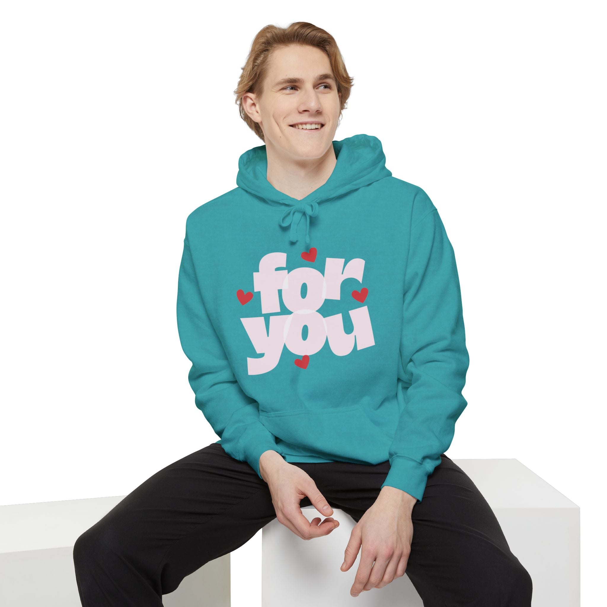 Person wearing a teal hoodie with 'For You' text and hearts on a white background