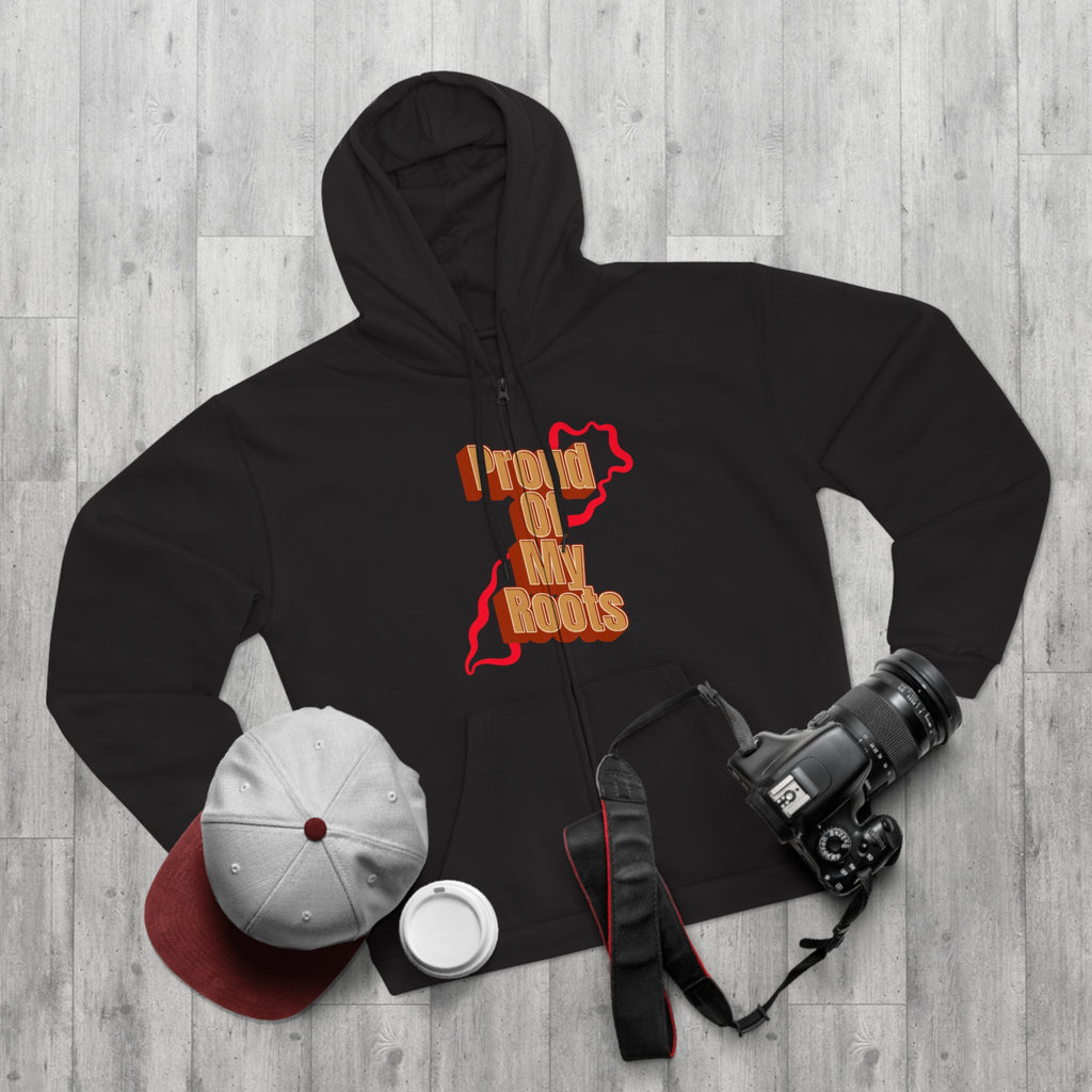 Black hoodie with 'Proud of My Roots' design on a wooden surface, surrounded by a cap, bottle, and camera.