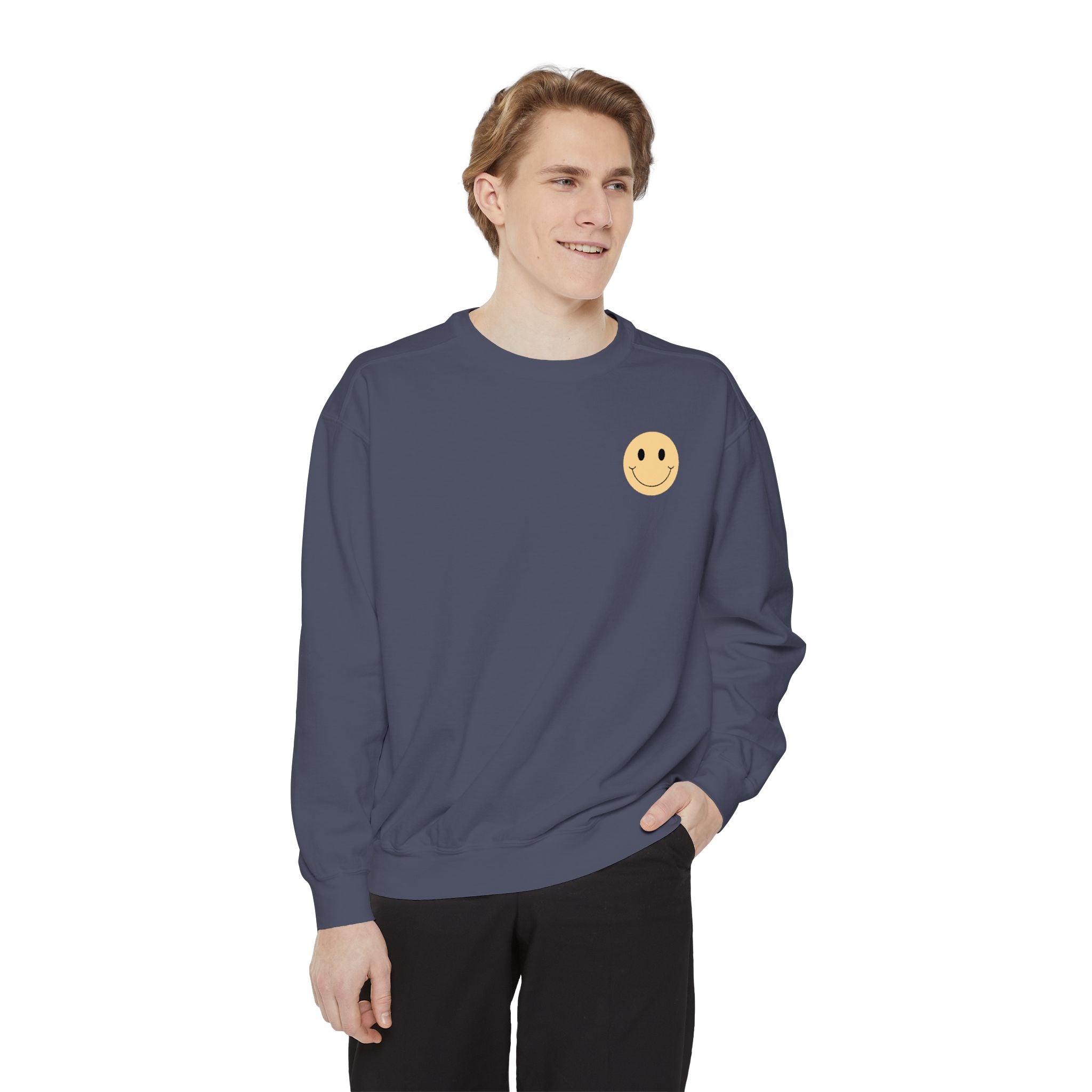 Person wearing a navy blue sweatshirt with a smiley face emblem on a white background