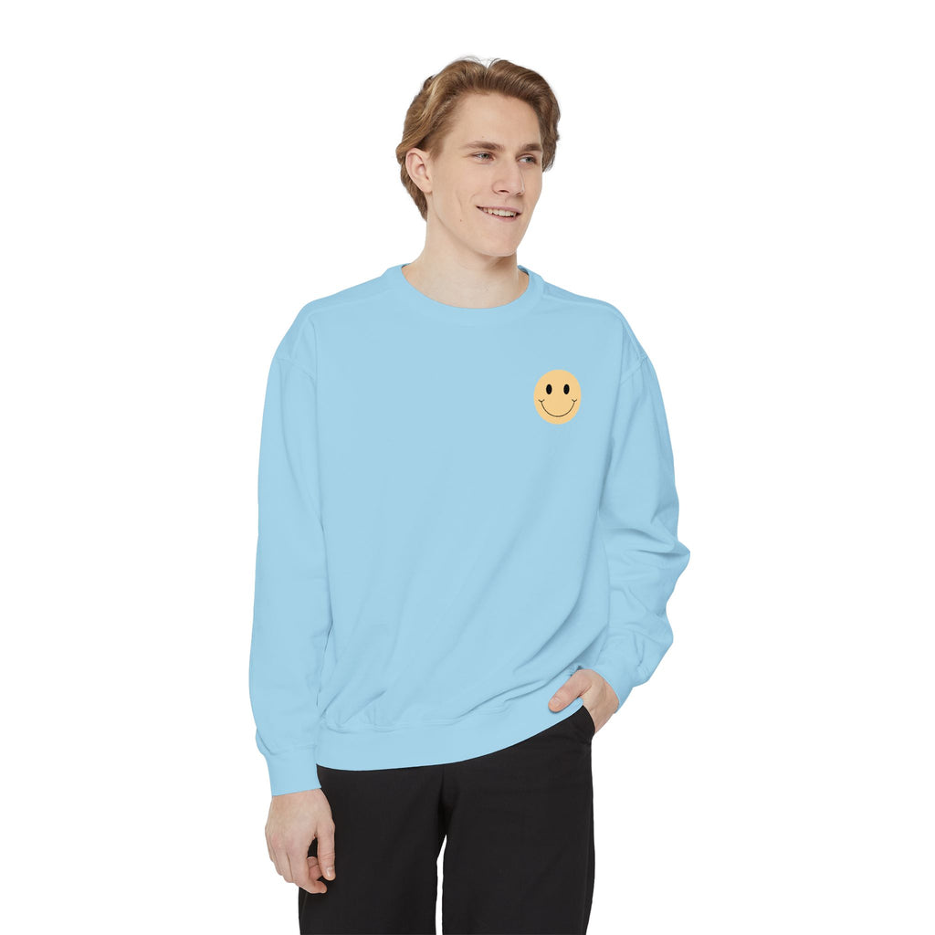 Person wearing a light blue sweatshirt with a smiley face emblem on a white background