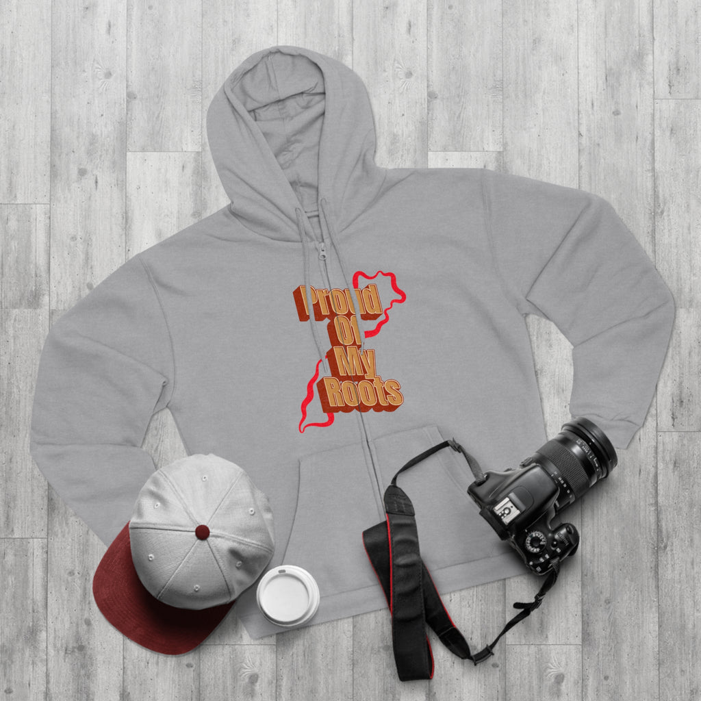 Gray hoodie with text, white cap, white mug, and camera on a wooden surface