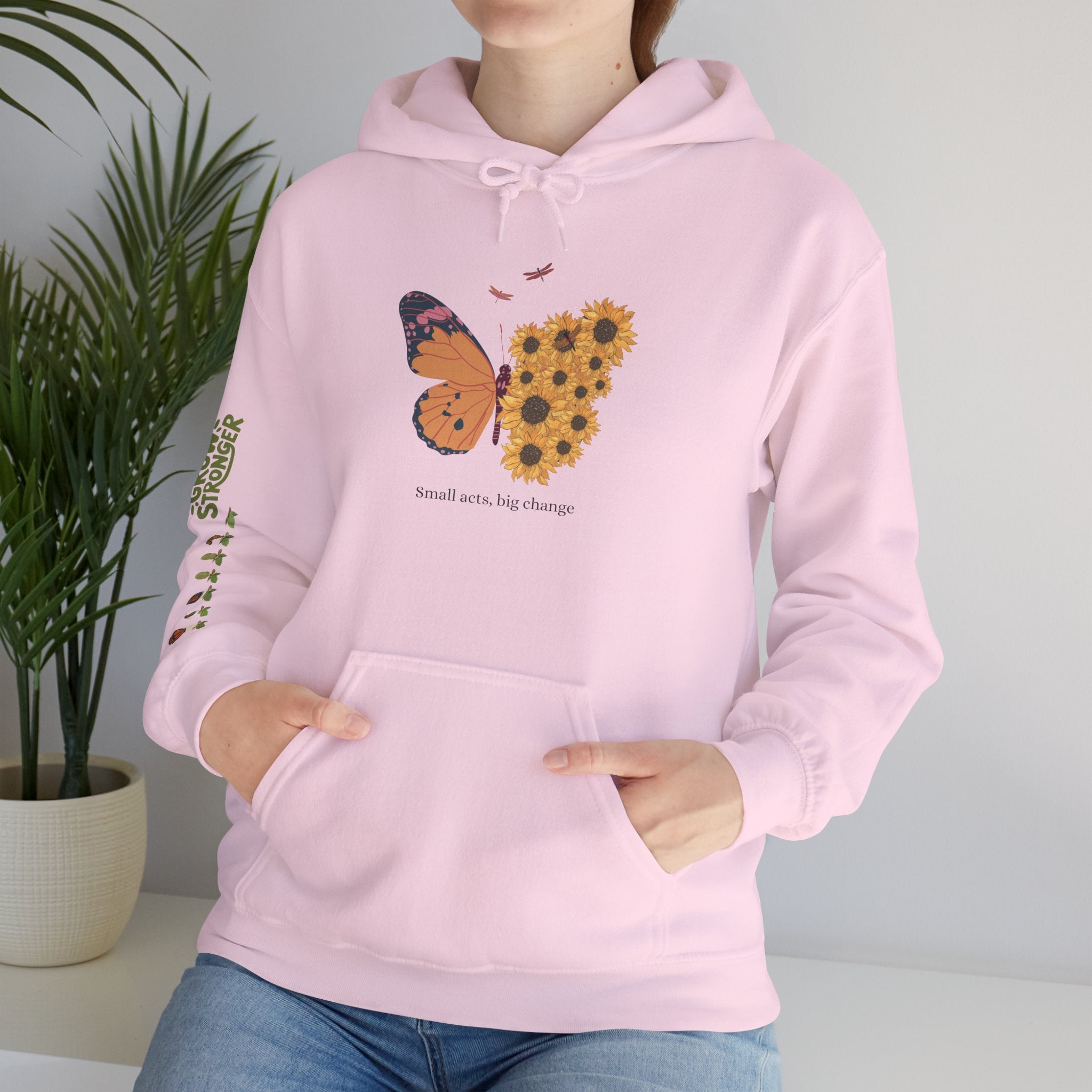 Person wearing a pink hoodie with a butterfly and sunflower design, standing against a plain background.