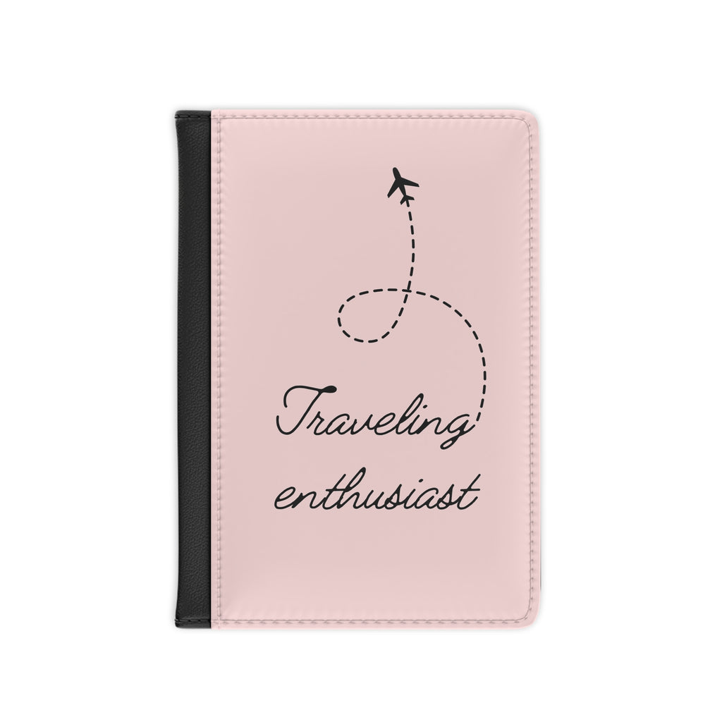 Pink passport holder with 'Traveling enthusiast' text and airplane icon on a white background