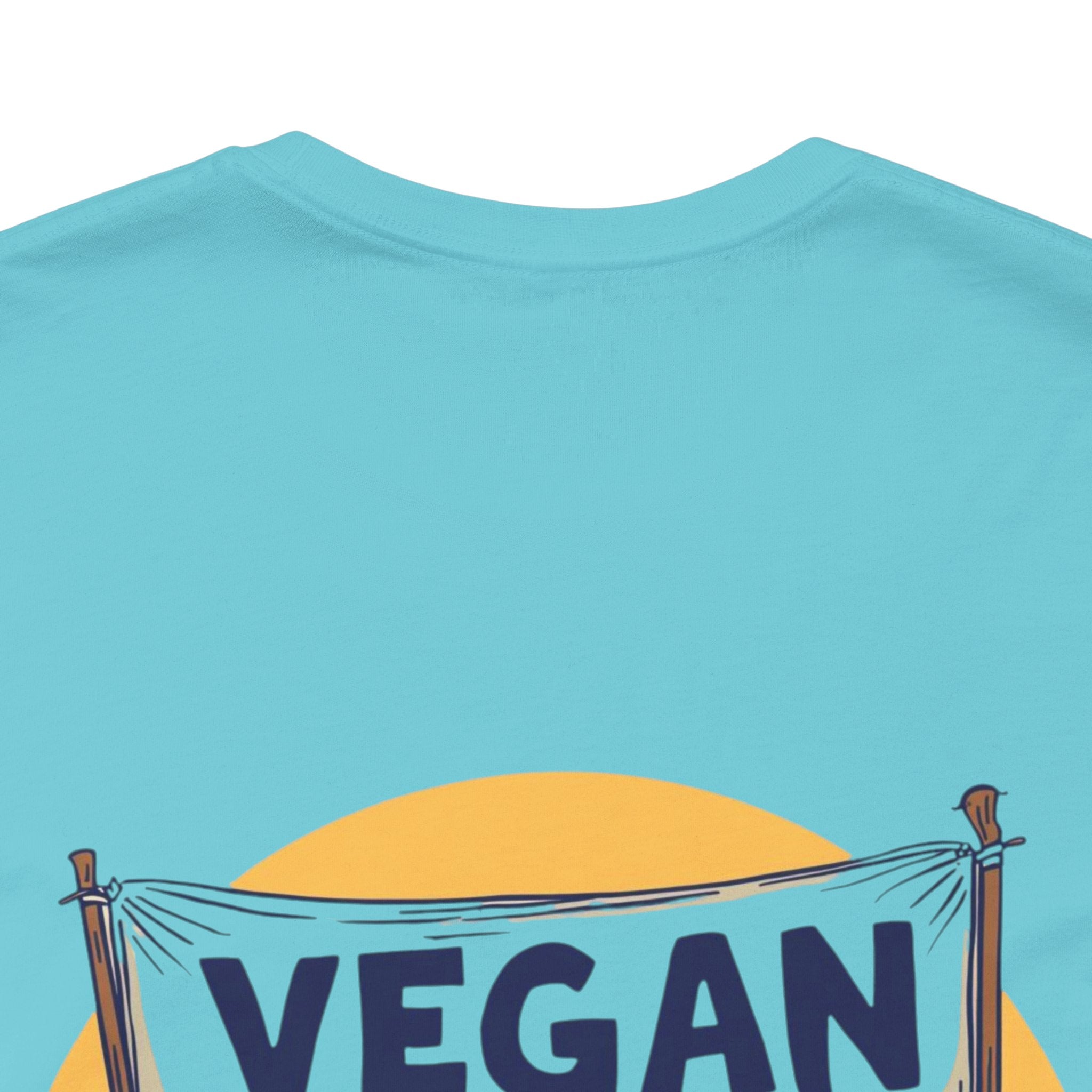 Blue t-shirt with 'VEGAN' text and sun design on a white background