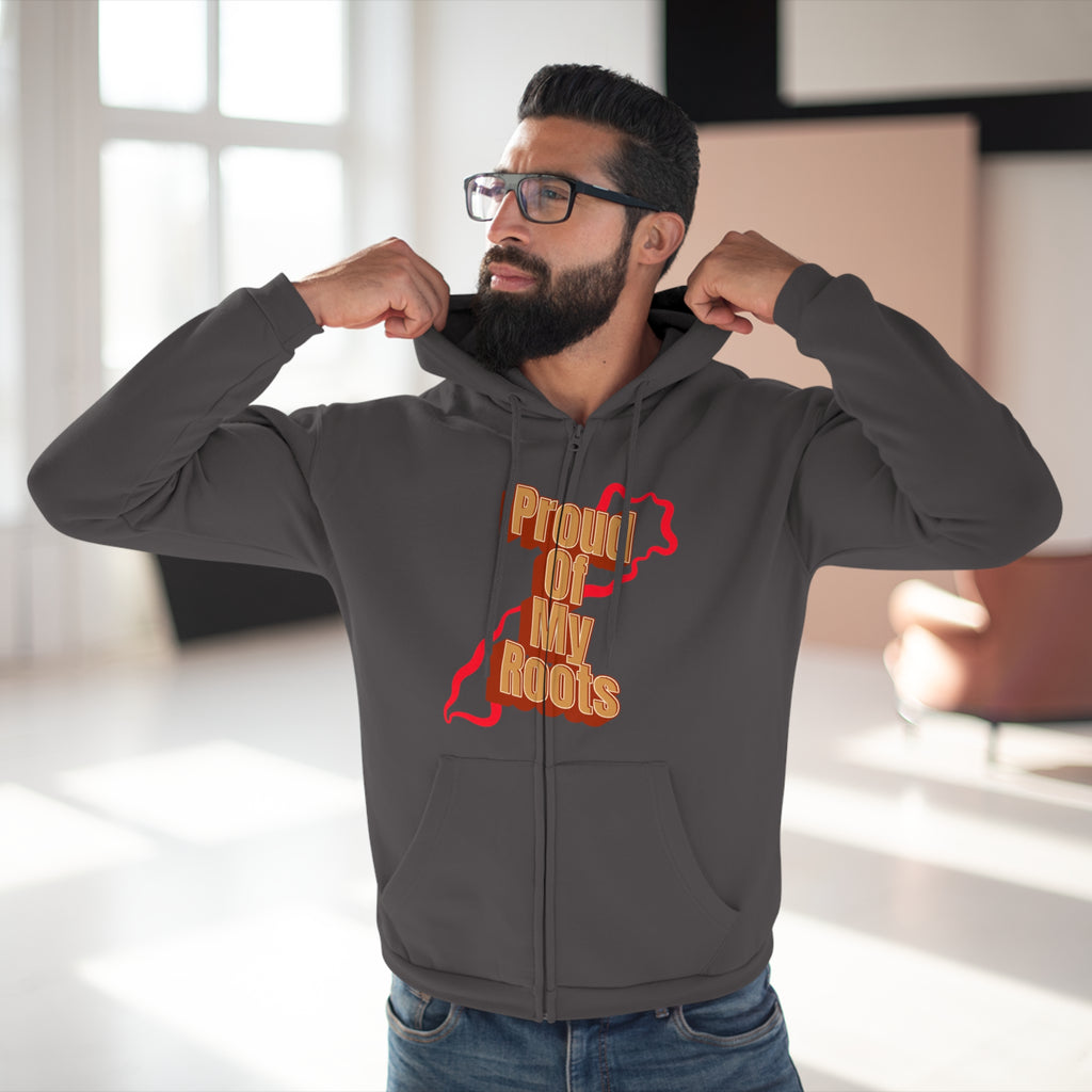 Man wearing a gray hoodie with 'Proud of My Roots' text and graphic indoors.