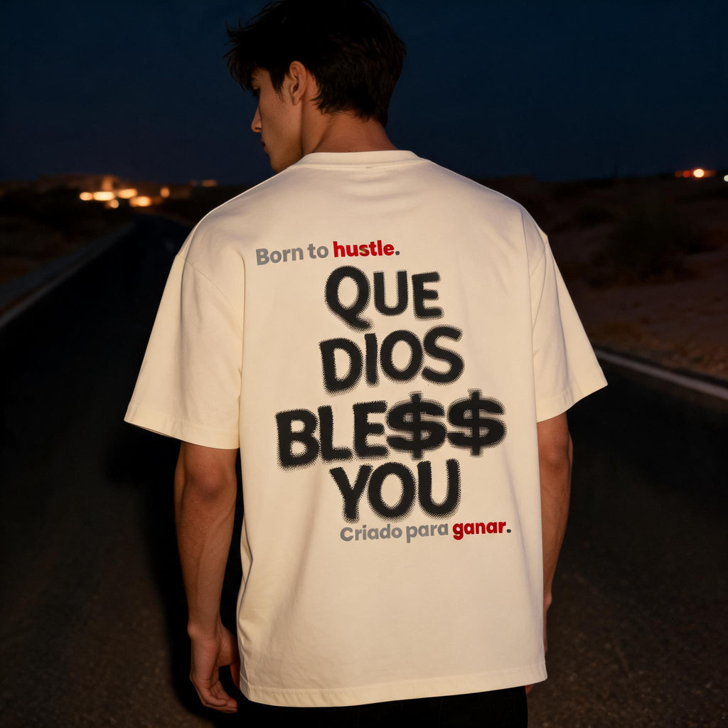 A man standing on a dark road at night, viewed from behind, wearing an off-white graphic T-shirt with Spanish text reading 'Born to hustle. QUE DIOS BLESS$ YOU Criado para ganar.