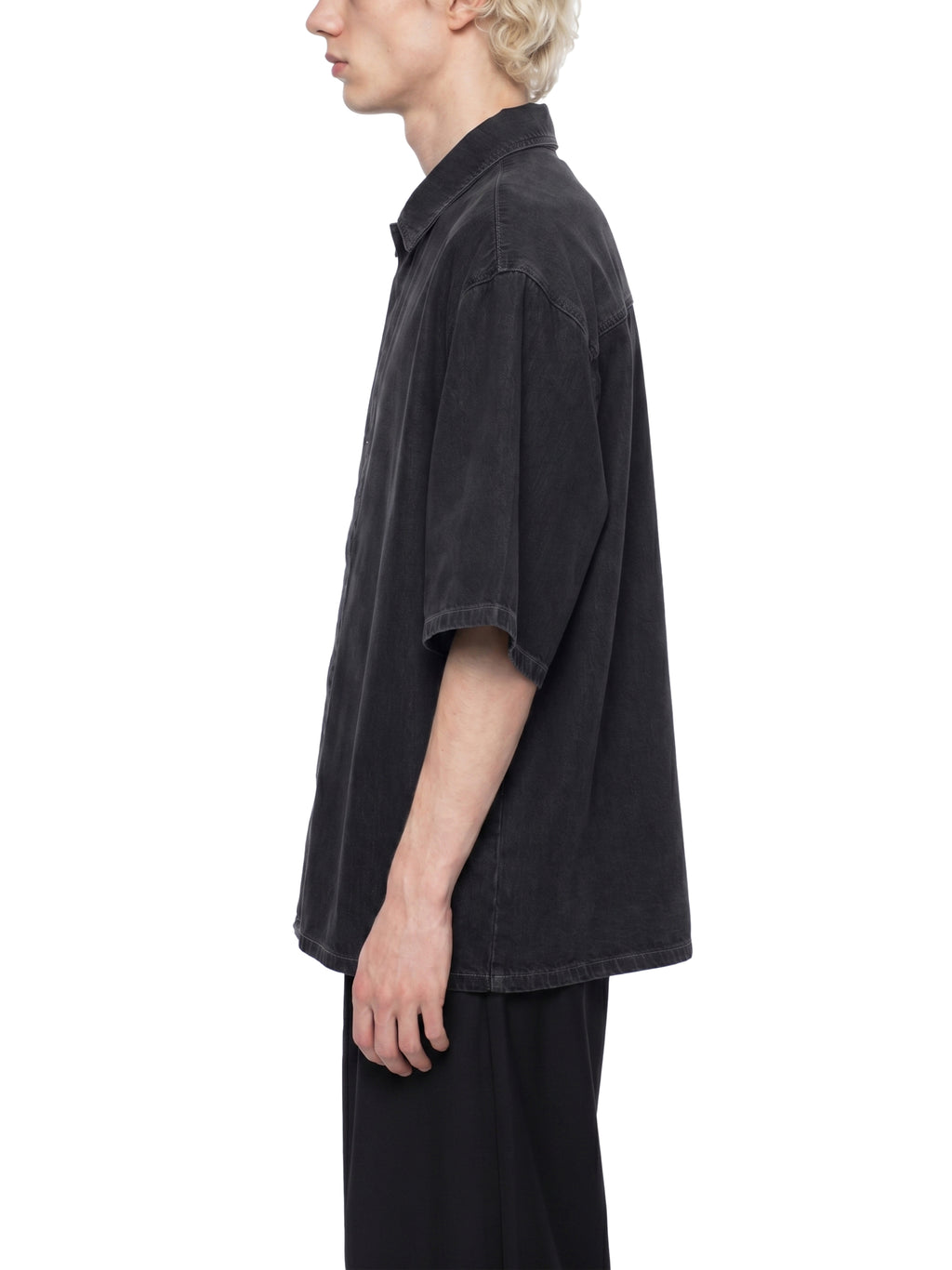 Person wearing a black oversized shirt on a white background