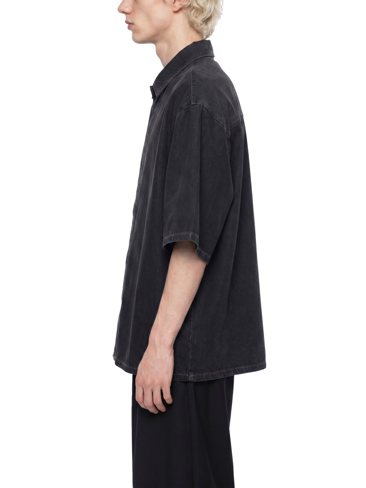 Person wearing a black oversized shirt on a white background