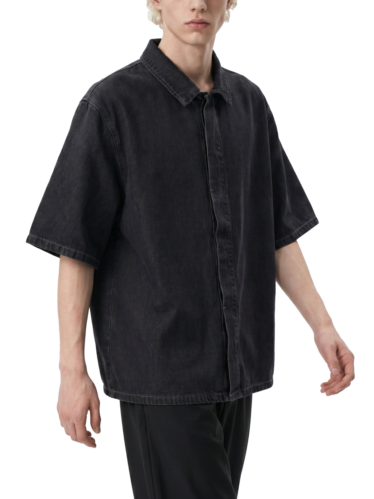 Person wearing a black oversized shirt on a white background