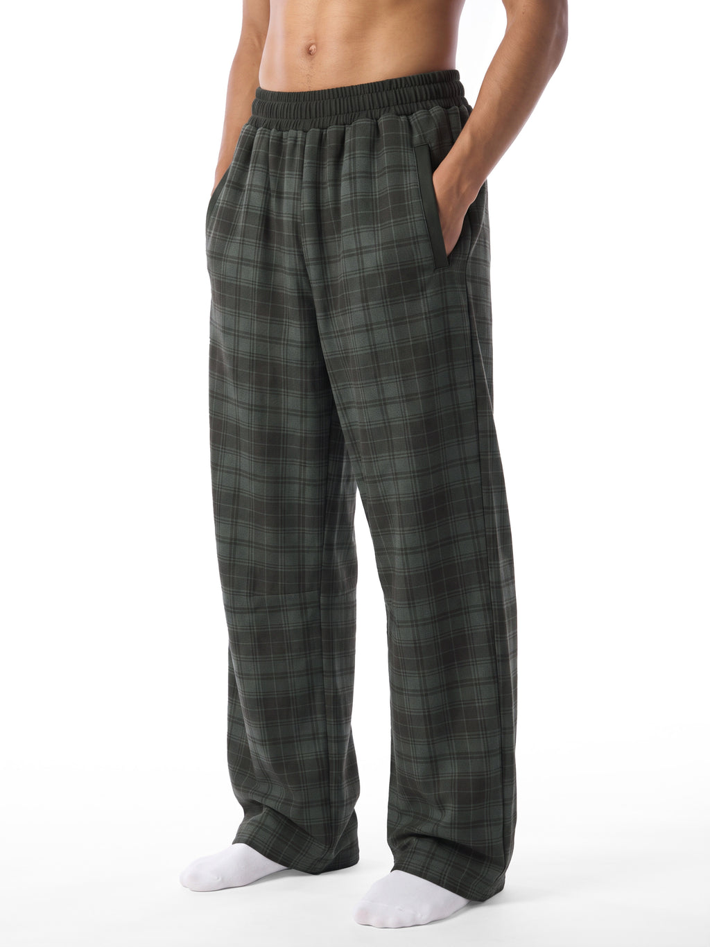 A person wearing dark green and gray plaid lounge pants with an elastic waistband, shown from the waist down against a plain white background.