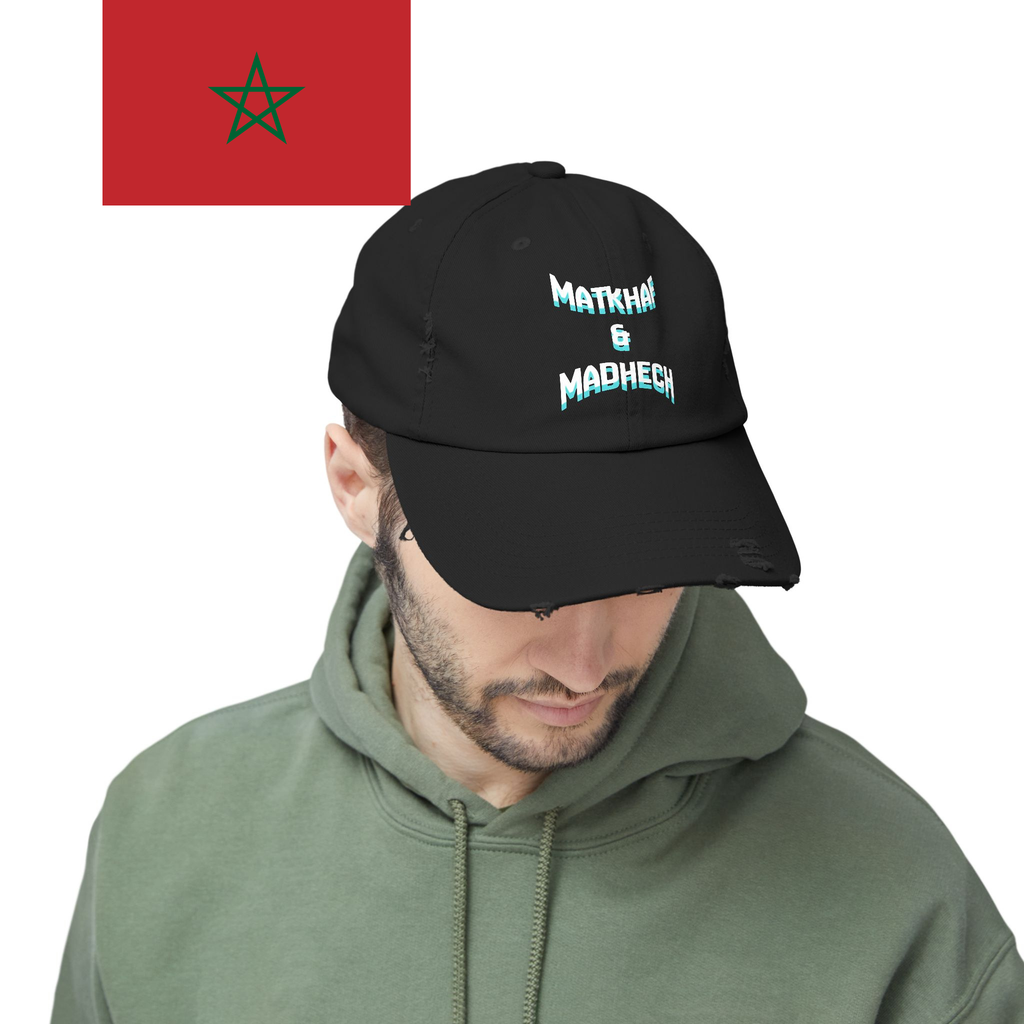 Man wearing a black cap with text and a green hoodie, with a flag of Morocco in the background.