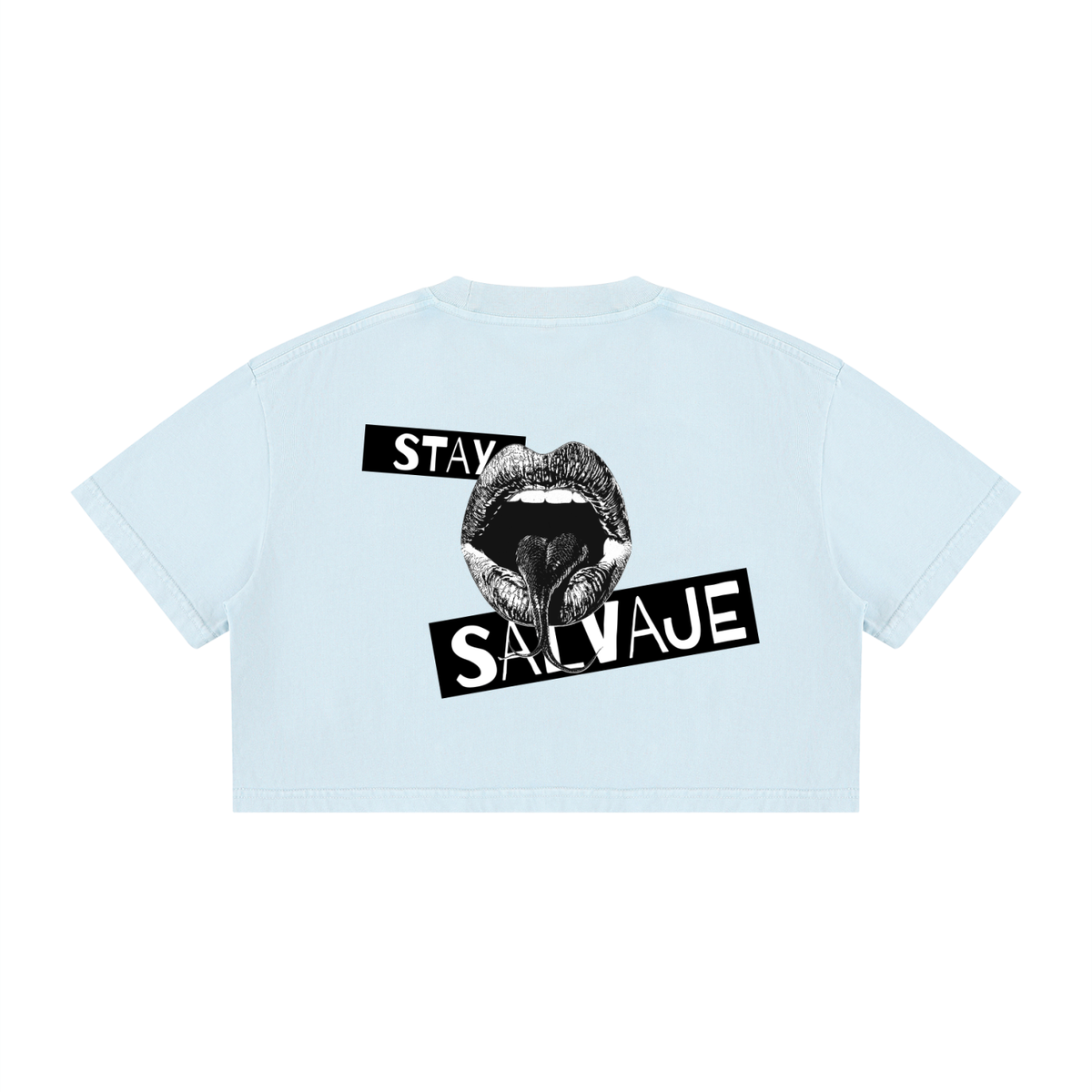 Un *crop top* de manga corta en color azul claro, visto desde atrás, que presenta un gráfico negro de una boca abierta con la lengua visible y las palabras «STAY SALVAJE» impresas en el centro.