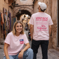 Two people wearing pink t-shirts with vintage car designs in a narrow 
Two people wearing t-shirts with vintage designs and text, set against a pastel-colored background street
Light pink t-shirt front SIMCA logo, back vintage car illustration L’Hirondelle de Casa text, ShowYourLove collection, Moroccan nostalgia design, retro automotive streetwear..
“Love vintage, love memories.”

“ShowYourLove, show your roots.”

“L’Hirondelle de Casa — timeless elegance.”

“Where nostalgia meets style.”