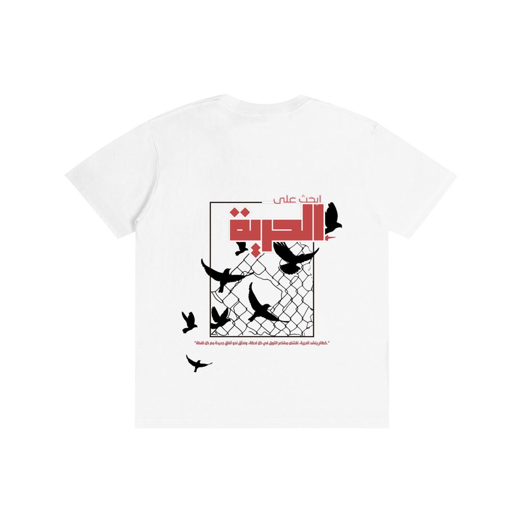 A white short-sleeve t-shirt with a graphic print on the front. The graphic features black silhouettes of flying birds, a chain-link fence, and red Arabic text.

قميص أبيض عليه حمامة تحمل غصن الزيتون في الأمام، وخلفية طيور سوداء تحطم سياجًا معدنيًا مع عبارة ابحث على الحرية، تصميم ShowYourWisdom عن السعي نحو الحرية والانعتاق.
"اكسر القفص، وطر."

"ShowYourWisdom، ابحث على الحرية."

"الحرية ليست حلمًا، بل قرارًا."

"من يملك الحرية، يملك الحياة."