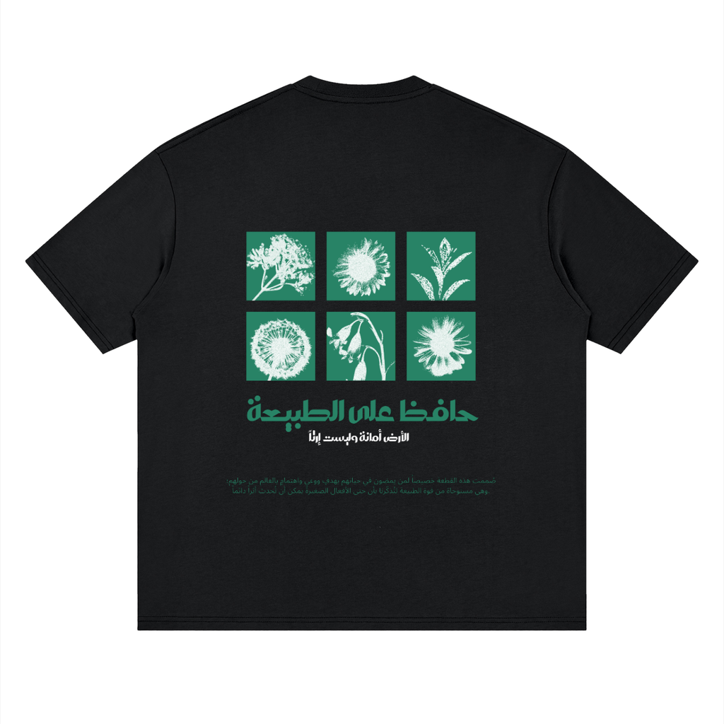 A black short-sleeve t-shirt shown flat against a white background, featuring a green graphic print on the front with six square panels of botanical illustrations and Arabic text below.
قميص أسود عليه رسم طريق بين الأشجار نحو كوكب في السماء مع عبارة الانسجام بالذات في الطبيعة، وخلفية نباتات وزهور مع عبارة حافظ على الطبيعة، تصميم ShowYourNature عن حماية البيئة والانسجام مع الأرض.