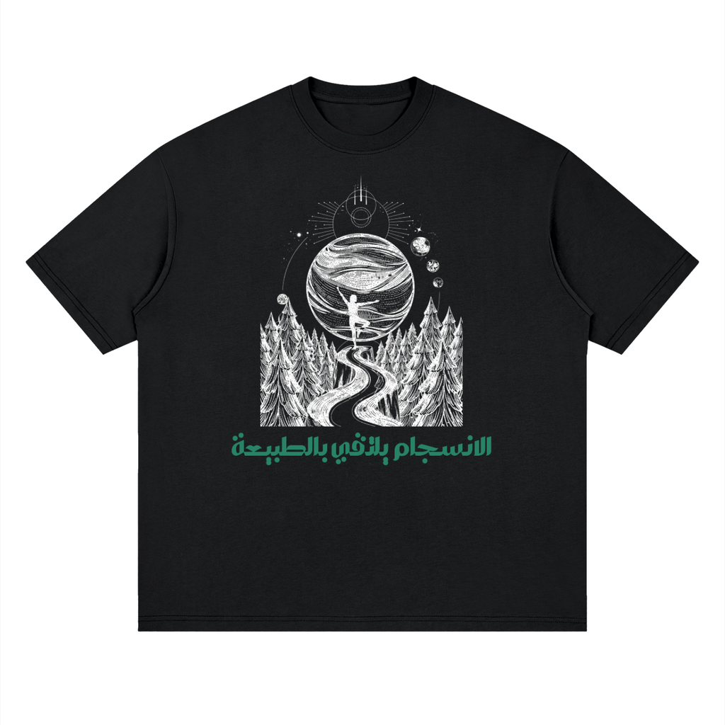 A black short-sleeve crewneck t-shirt featuring a white line art graphic of a person standing on a hill overlooking a forest and a planet, with green Arabic text printed below.
قميص أسود عليه رسم طريق بين الأشجار نحو كوكب في السماء مع عبارة الانسجام بالذات في الطبيعة، وخلفية نباتات وزهور مع عبارة حافظ على الطبيعة، تصميم ShowYourNature عن حماية البيئة والانسجام مع الأرض.