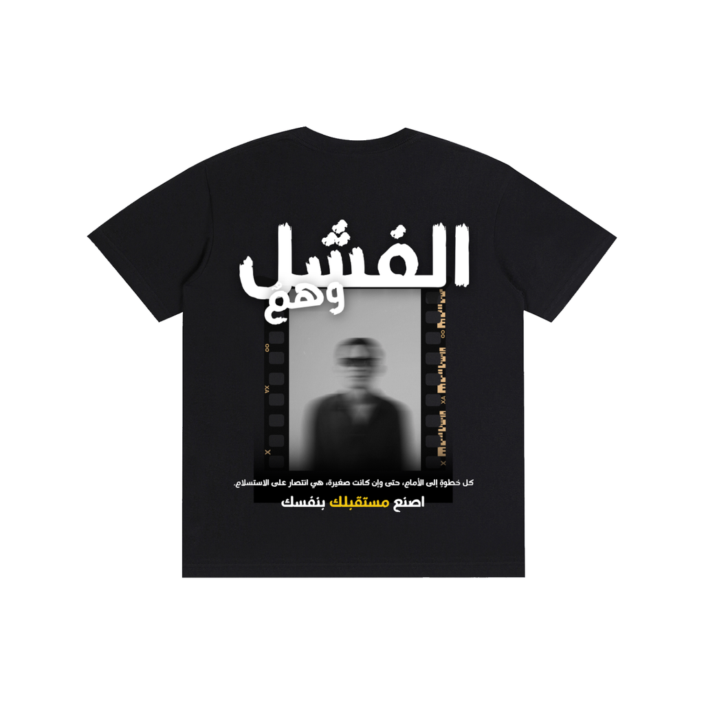 A black short-sleeve t-shirt with a large graphic print on the front featuring Arabic text in white and yellow, a vertical film strip border, and a blurred portrait of a man.
قميص أسود عليه عبارة الفشل وهم وصورة ضبابية لشخص، مع اقتباس كل خطوة إلى الأمام هي انتصار على الاستسلام، تصميم ShowYourWisdom عن الإصرار والتغلب على الفشل.
"الفشل ليس نهاية، بل بداية جديدة."

"ShowYourWisdom، اصنع مستقبلك بنفسك."

"كل سقوط هو خطوة نحو النهوض."

"الوهم الوحيد هو أن تتوقف عن المحاولة."